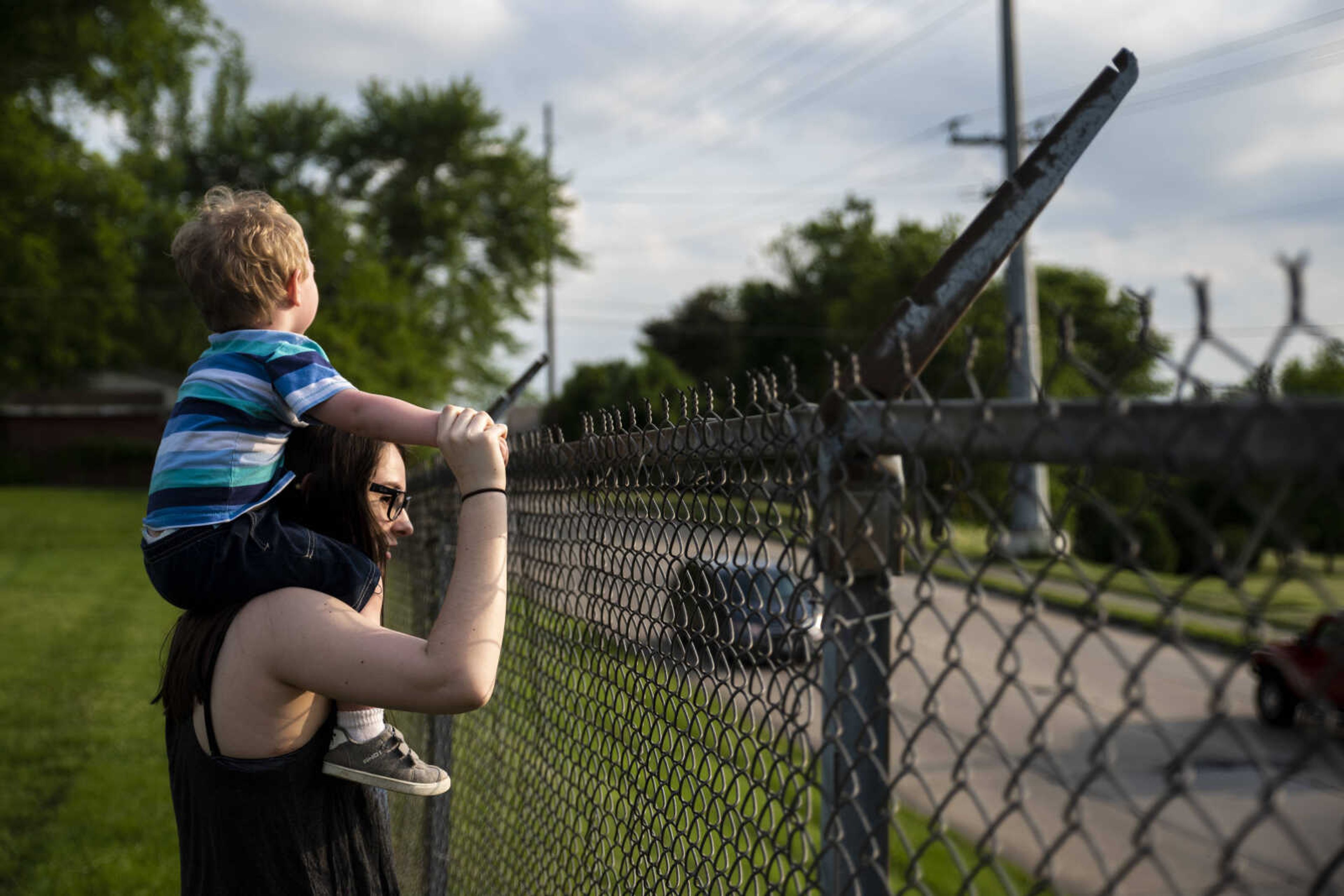 Emily Medlock holds her son Phoenix Young, 2, on her shoulders in the field behind the house as they watch cars go by Tuesday, May 7, 2019, in Cape Girardeau. Emily said one of Phoenix's favorite things to do is to watch the cars drive by along the fence line.