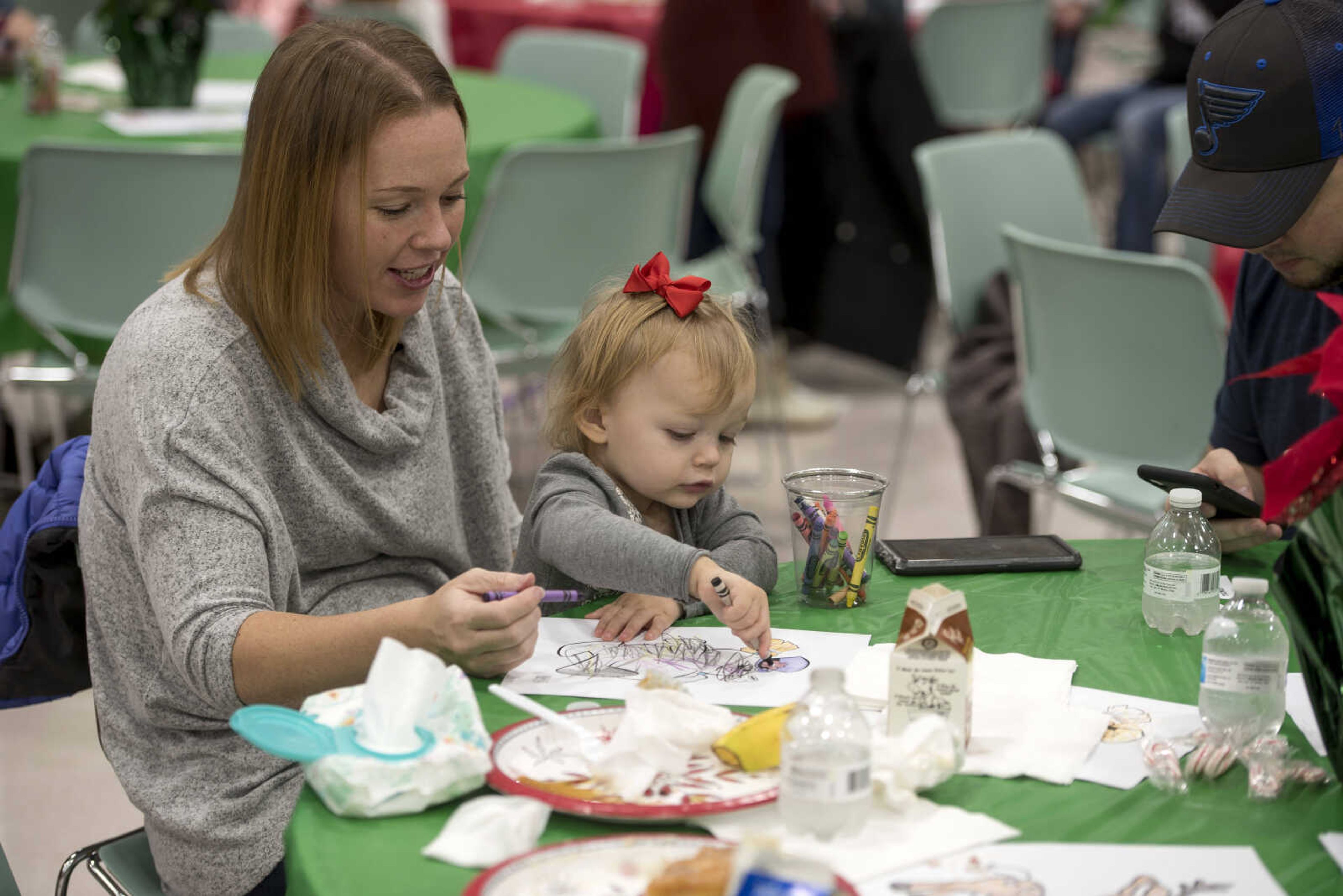 Jessica McDonald and Aubrey McDonald, 2, color with crayons during a family breakfast with Santa at the Osage Center Saturday, Dec. 15, 2018.