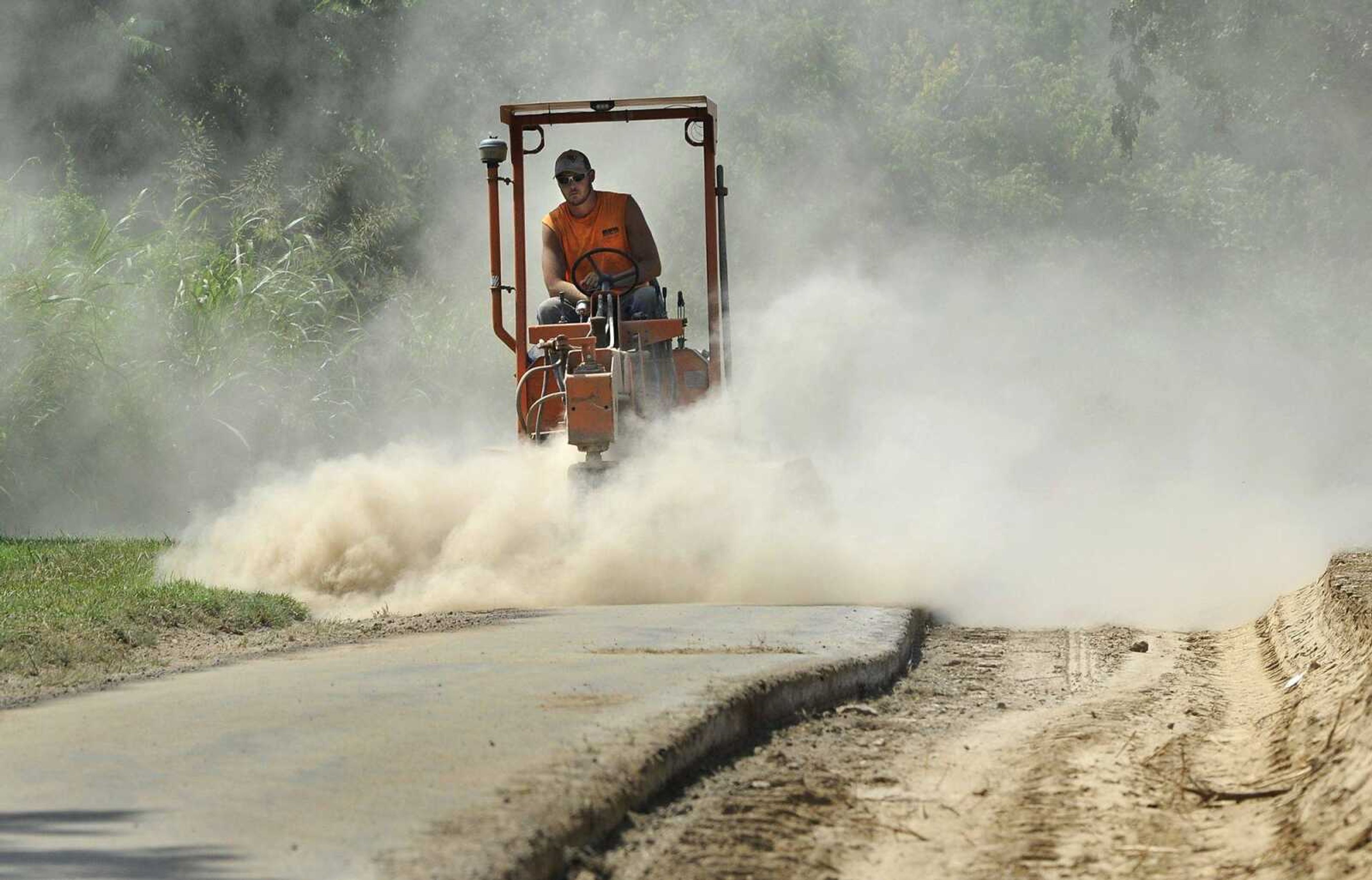 Quinn Poythress with ASA Asphalt Inc. operates a power brush Thursday on a section of the Cape LaCroix Recreation Trail near Arena Park in Cape Girardeau. The trail is being widened from 8 feet to 10 feet from East Rodney Drive to Hopper Road. Revenue from the city's parks and recreation and stormwater sales tax and the casino fund will pay for the more than $255,000 project.