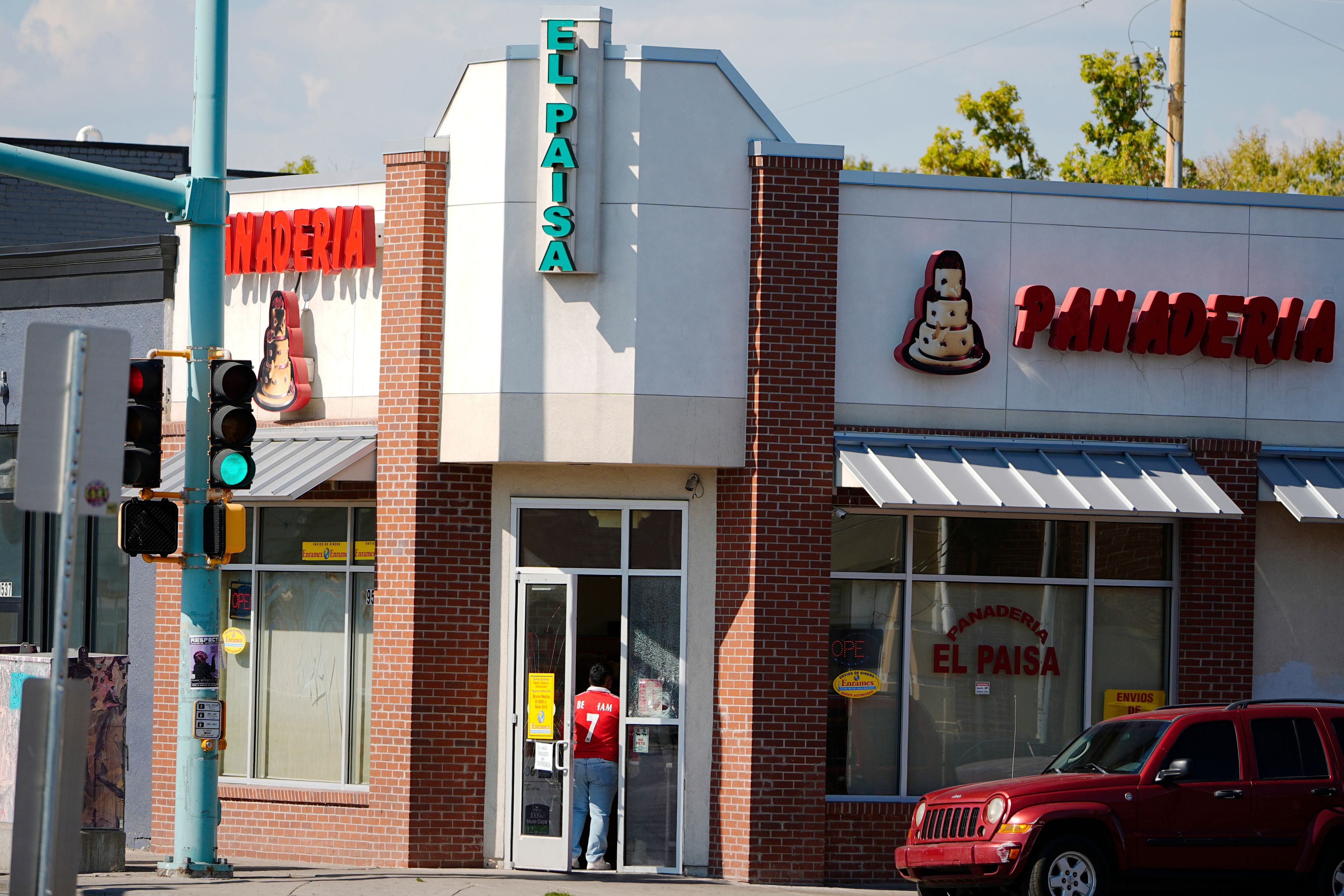 A shopper waits to enter a Mexican bakery at the corner of East Colfax Avenue at Dallas Street, Wednesday, Oct. 9, 2024, in the east Denver suburb of Aurora, Colo. (AP Photo/David Zalubowski)