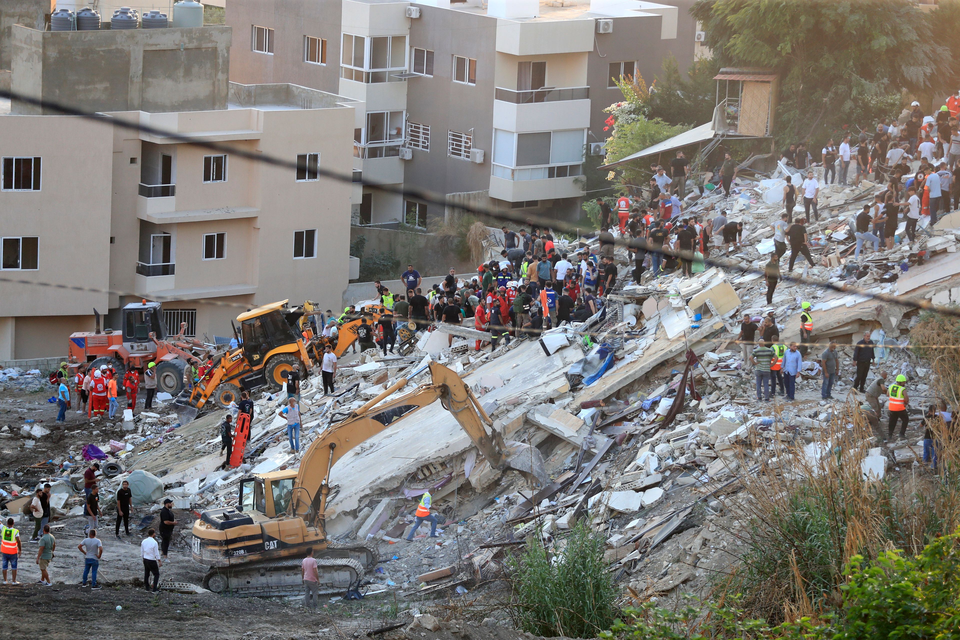 FILE - People and rescue teams search for victims after an Israeli airstrike hit two adjacent buildings, in Ain el-Delb neighbourhood east of the southern port city of Sidon, Lebanon, Sunday, Sept. 29, 2024. (AP Photo/Mohammed Zaatari, File)