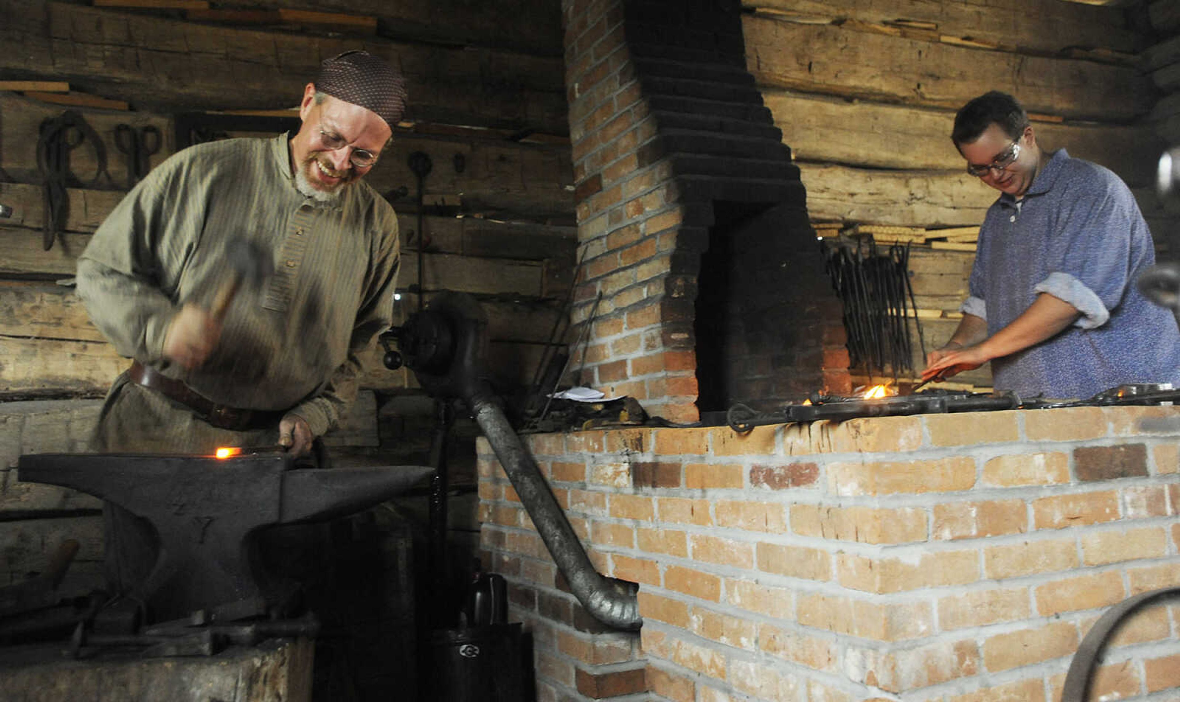 Blacksmiths Ian Willie, right, and Mark Petzoldt, left, make nails as visitors look on at the Saxon Lutheran Memorial's Fall Festival Saturday, October 13, in Frohna. The annual festival celebrates the heritage of the area's 19th century German immigrants.