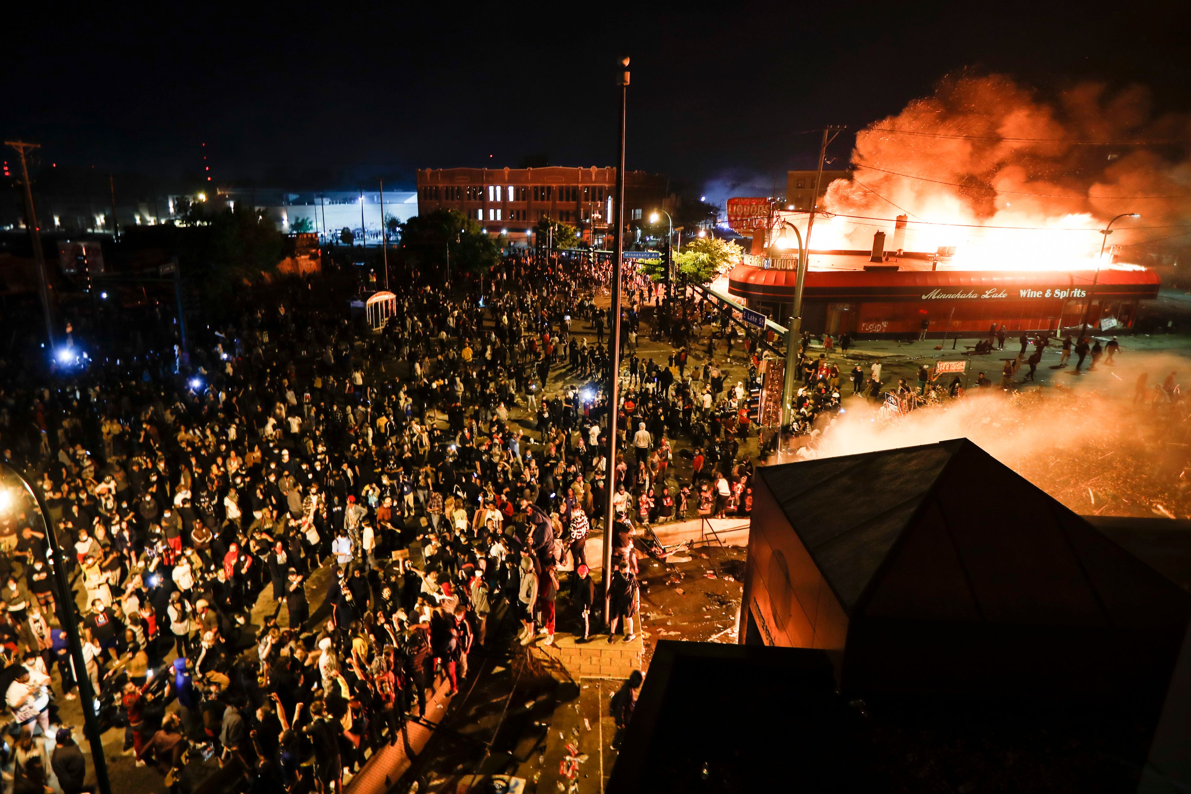 FILE - Protestors demonstrate outside of a burning Minneapolis 3rd Police Precinct, on May 28, 2020, in Minneapolis. (AP Photo/John Minchillo, File)