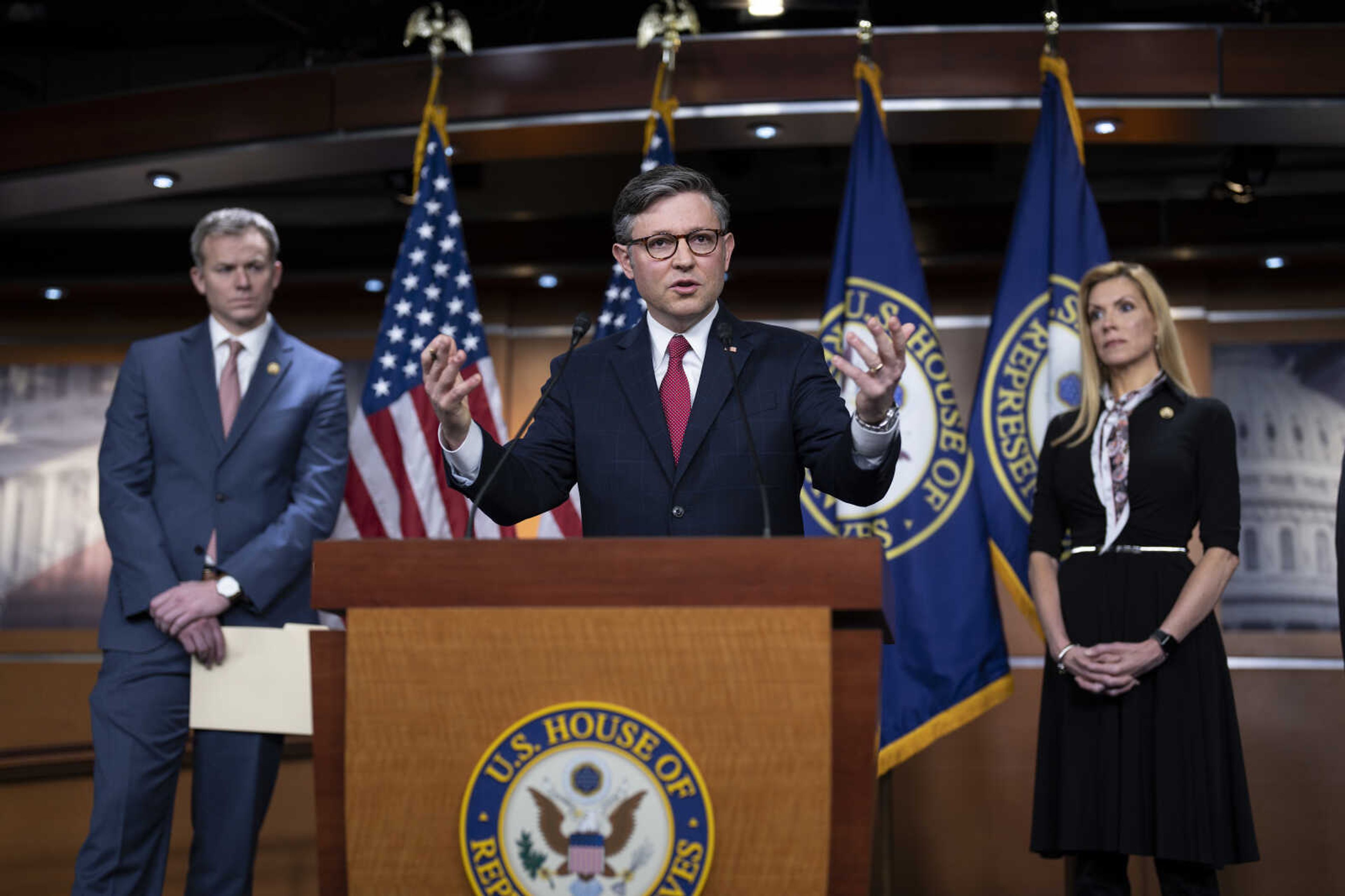 Speaker of the House Mike Johnson, R-La., center, flanked by Rep. Blake Moore, R-Utah, left, and Rep. Beth Van Duyne, R-Texas, discusses President Joe Biden's policies at the Mexican border during a news conference at the Capitol on Thursday in Washington.