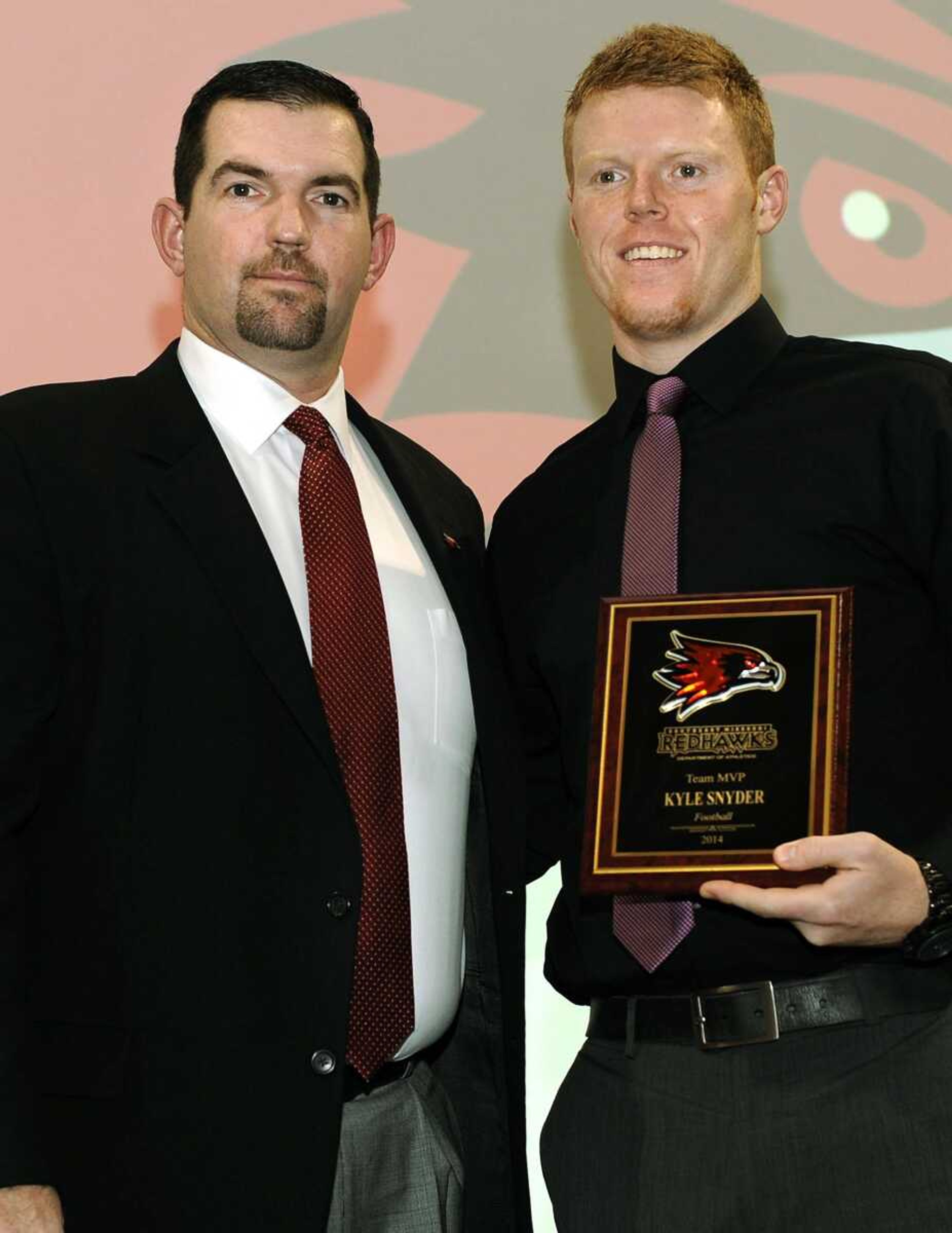 Southeast Missouri State coach Tom Matukewicz, left, presents the Team MVP award to quarterback Kyle Snyder during the inaugural Football Awards luncheon Sunday at the Student Recreation Center-North. (Fred Lynch)