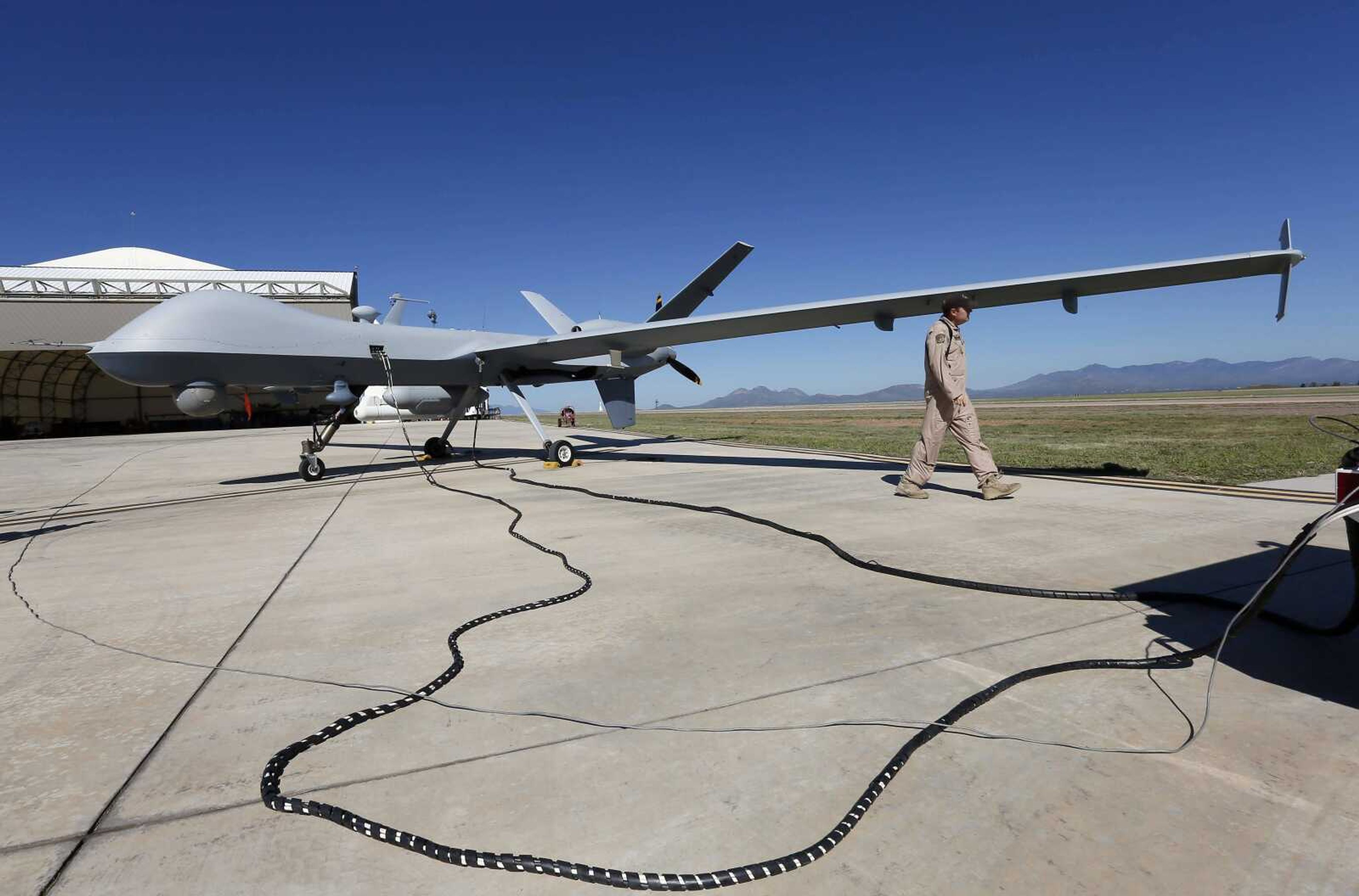 A U.S. Customs and Border Patrol drone aircraft is prepped near a hangar before its flight Wednesday at Fort Huachuca in Sierra Vista, Arizona. The U.S. government now patrols nearly half the Mexican border by drones alone. (Matt York ~ Associated Press)