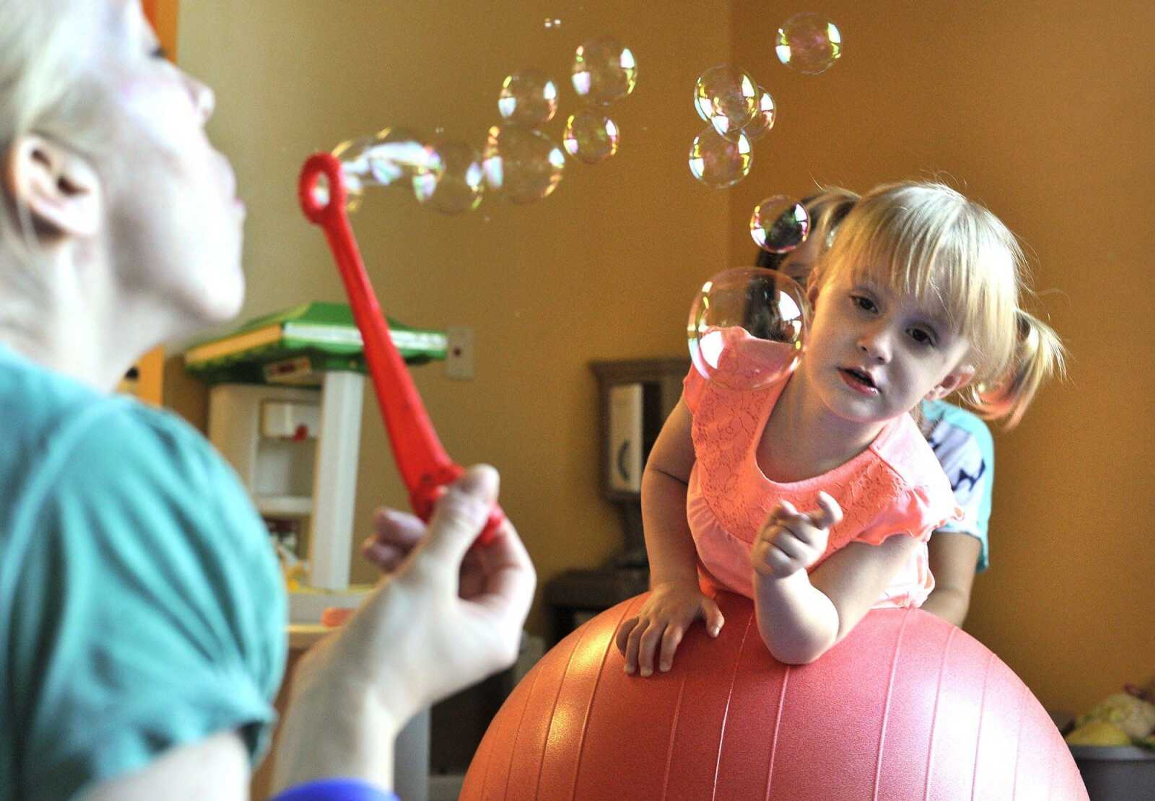 Jordyn Conn works with a physical therapist as her mother, Amber Conn, assists by blowing bubbles Thursday, Aug. 11, 2016 at HealthPoint Rehabilitation in Cape Girardeau.