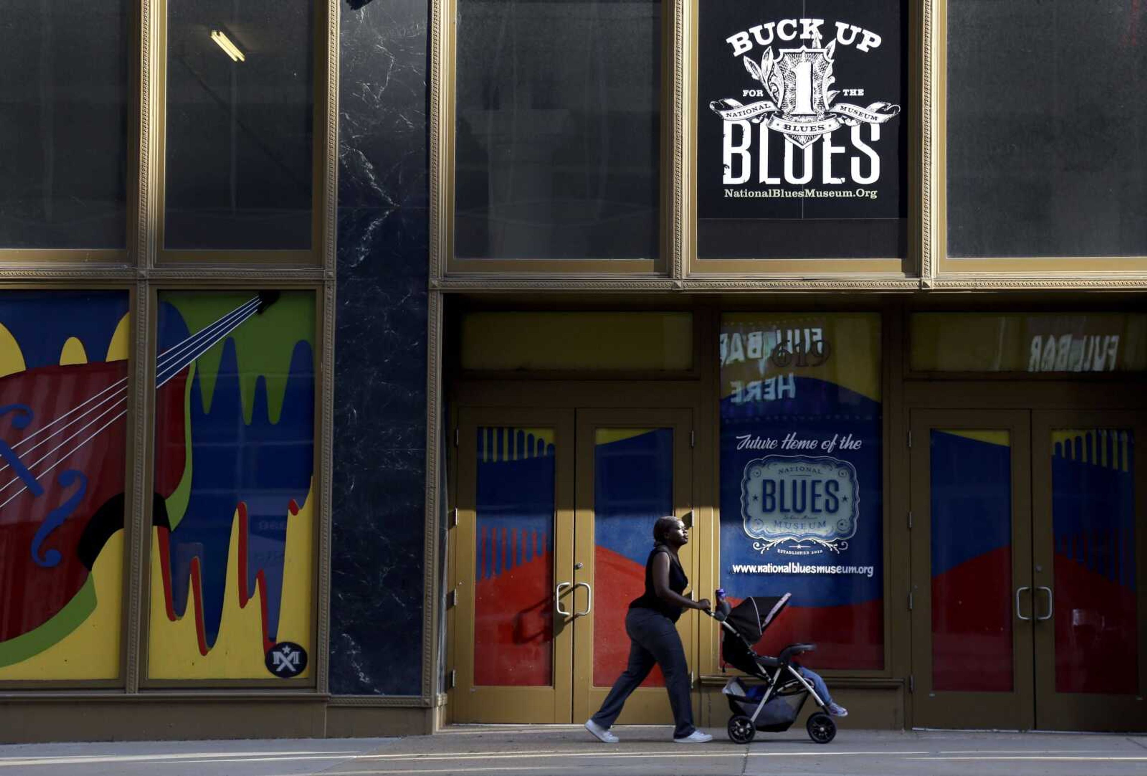 A woman pushes a stroller past the National Blues Museum, set to open next year in St. Louis. (Jeff Roberson ~ Associated Press)