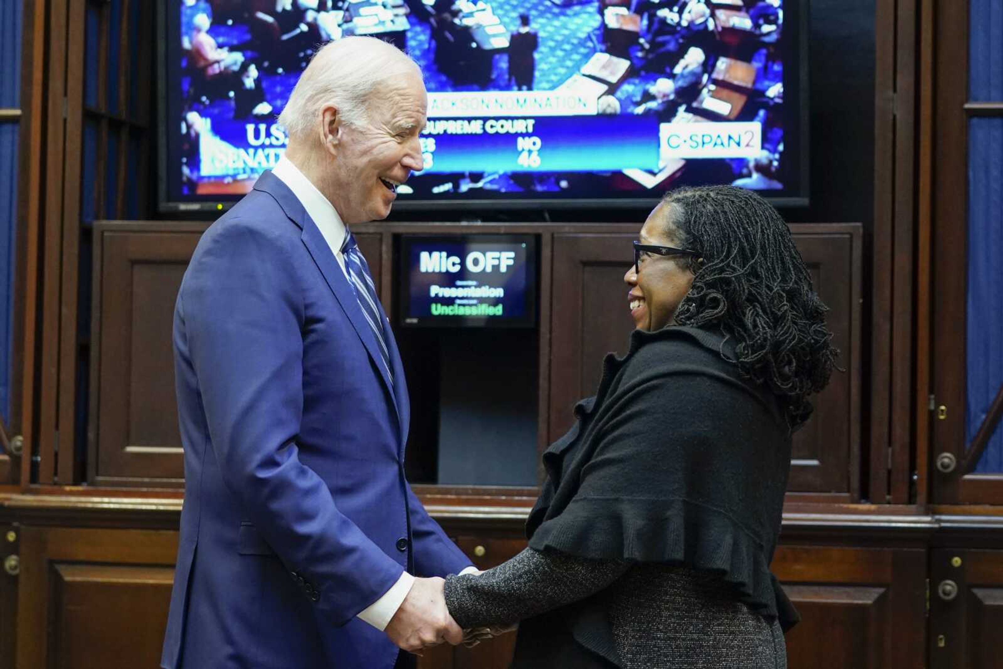 President Joe Biden holds hands with Supreme Court nominee Judge Ketanji Brown Jackson on Thursday as they watch the Senate vote on her confirmation from the Roosevelt Room of the White House in Washington.