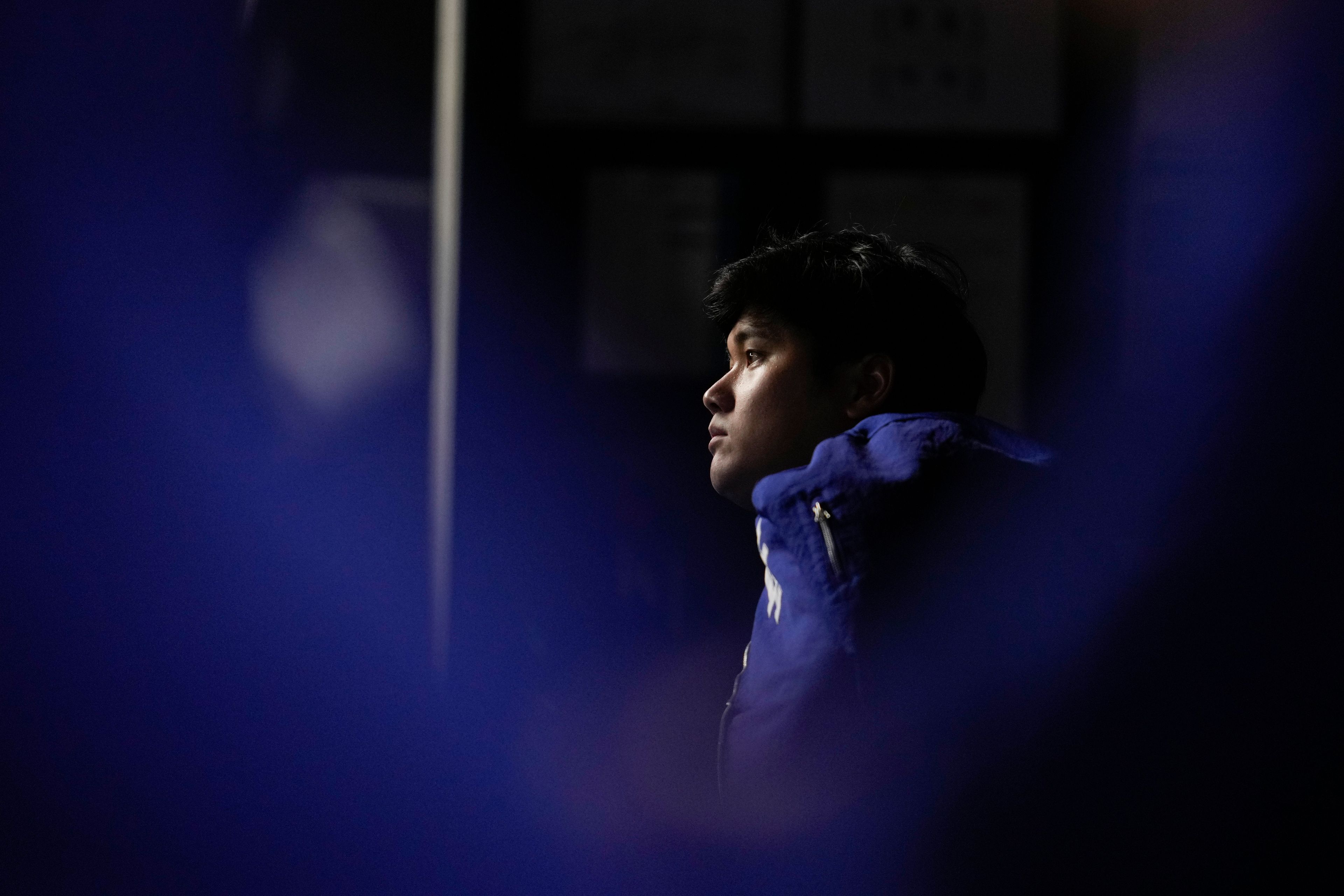 Los Angeles Dodgers' Shohei Ohtani watches in the dugout during the first inning in Game 5 of the baseball World Series against the New York Yankees, Wednesday, Oct. 30, 2024, in New York. (AP Photo/Ashley Landis)