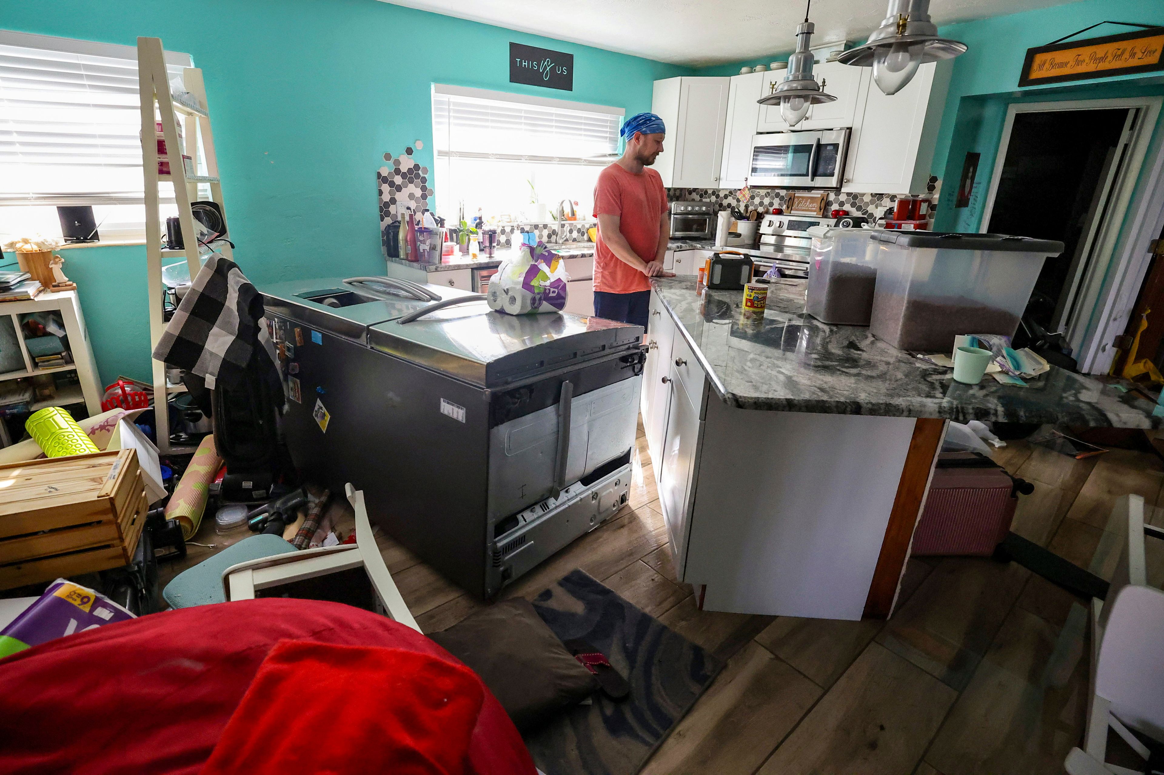 Bradley Tennant looks through his house flooded with water from Hurricane Helene in the Shore Acres neighborhood Friday, Sept. 27, 2024, in St. Petersburg, Fla. (AP Photo/Mike Carlson)