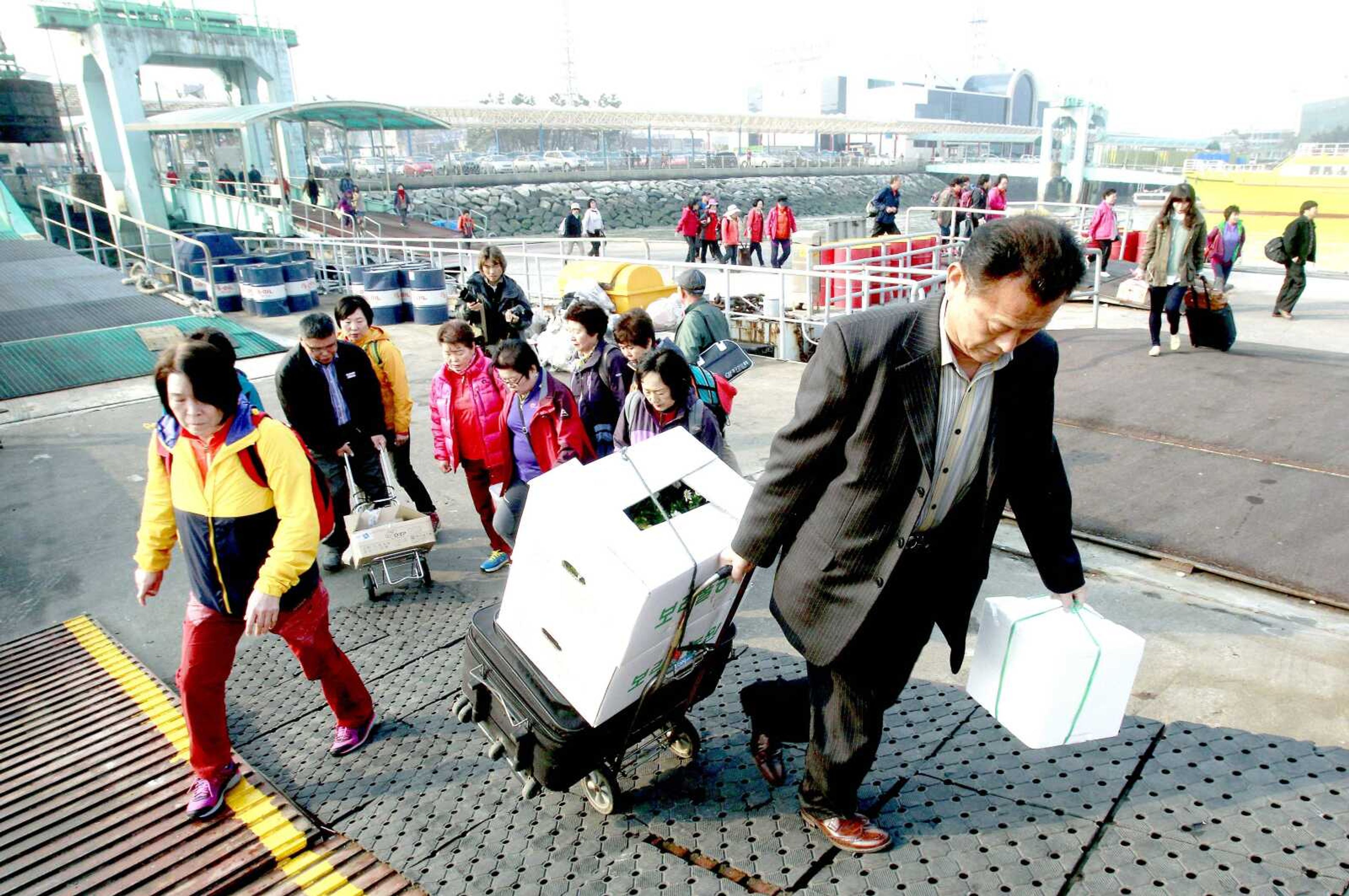 Passengers board a ship leaving for Yeonpyeong island Tuesday at Incheon port, South Korea. (Ahn Young-joon ~ Associated Press)