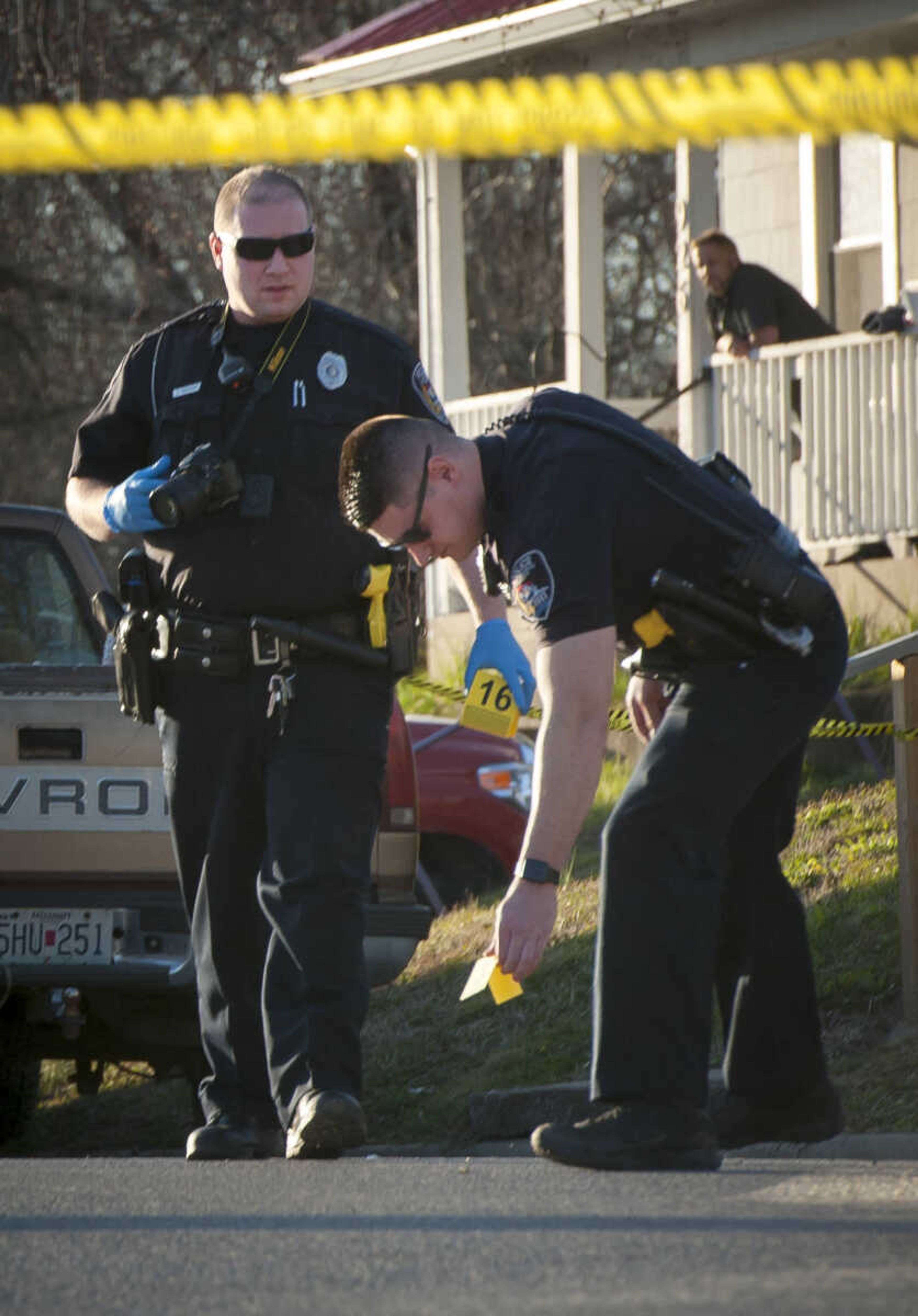 Cape Girardeau police officers place evidence markers in the 900 block of College Street on Tuesday, March 3, 2020, in Cape Girardeau.