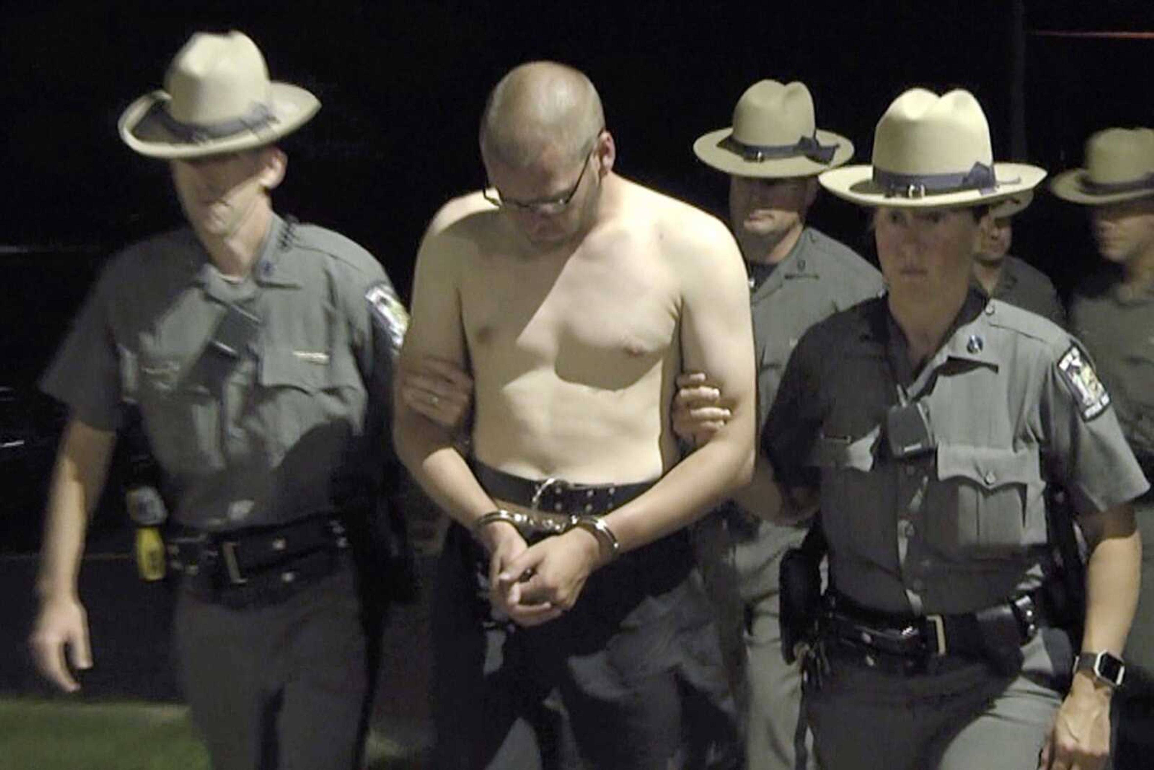 Army Staff Sgt. Justin Walters is escorted by New York State Police officers Monday outside the Le Ray Town Court in Le Ray, New York, after authorities said Walters killed his wife and state trooper Joel Davis, 36, who had responded to reports of shots fired at the couple's property.