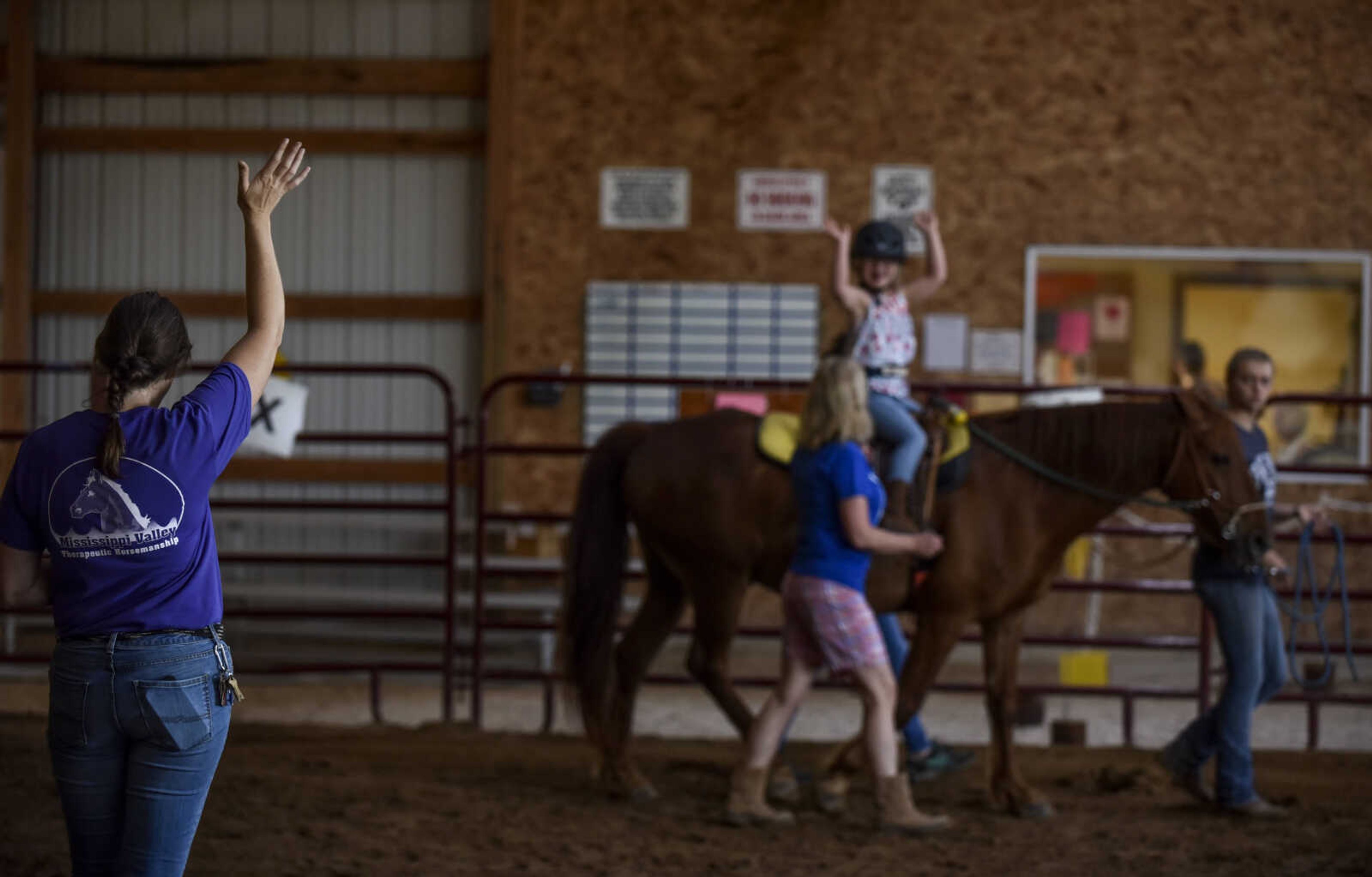 Lindyn Davenport, center, rides Ranger, 15, while performing stretches as coached by instructor Varina Luttrull, program director, during a summer camp session at Mississippi Valley Therapeutic Horsemanship Friday, June 8, 2018 in Oak Ridge.