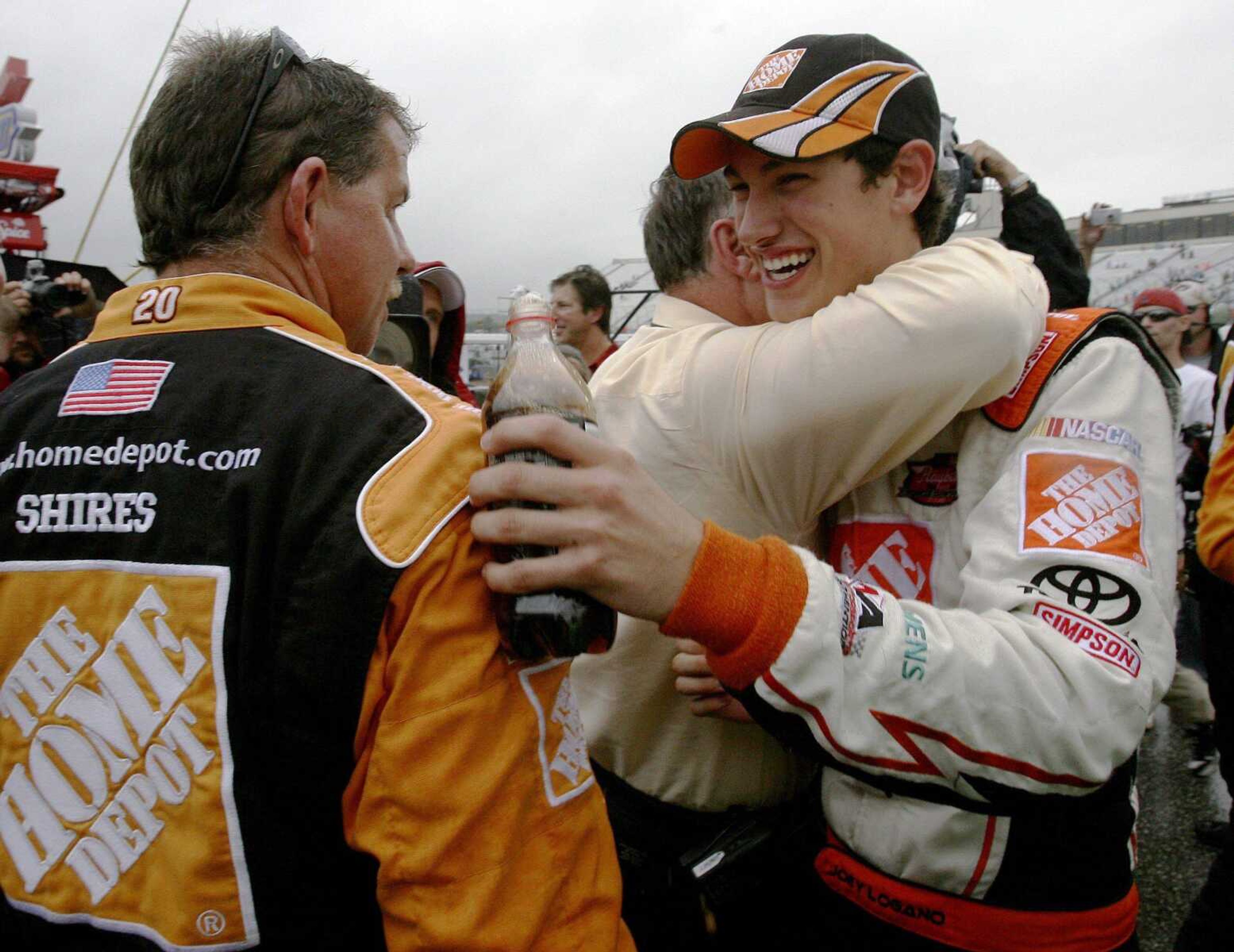 Joey Logano is congratulated by team owner Joe Gibbs on Sunday after winning the rain-shortened NASCAR Lenox Industrial Tools 301 at New Hampshire Motor Speedway in Loudon, N.H. (JIM COLE ~ Associated Press)