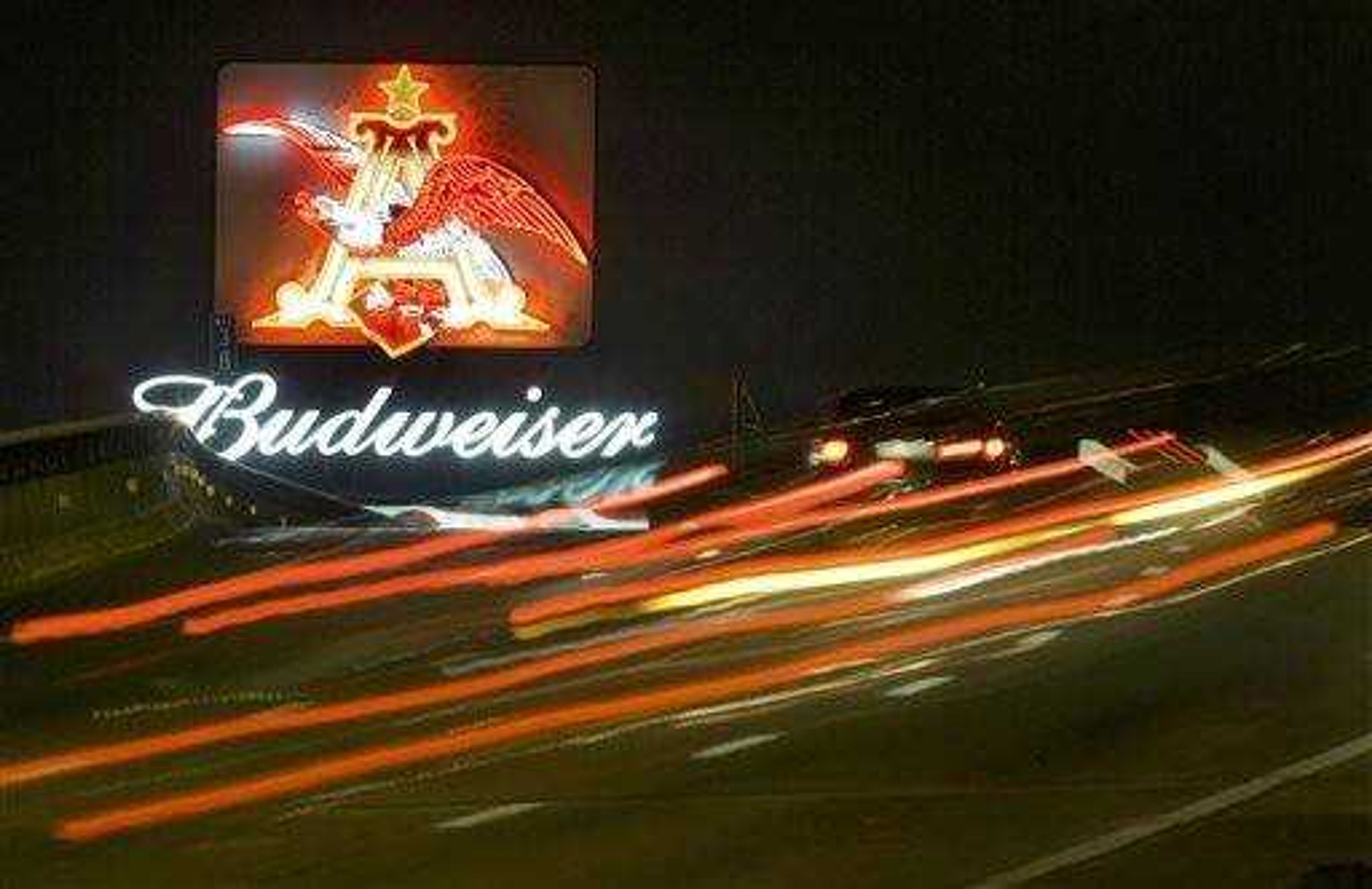 FILE - In this July 24, 2007 file photo Cars stream past a sign advertising Budweiser beer, in St. Louis. Anheuser-Busch is launching a wheat version of Bud Light this fall as it looks to keep growing the momentum of its best-selling brand by tapping into the growing wheat segment. (AP Photo/Jeff Roberson, File)