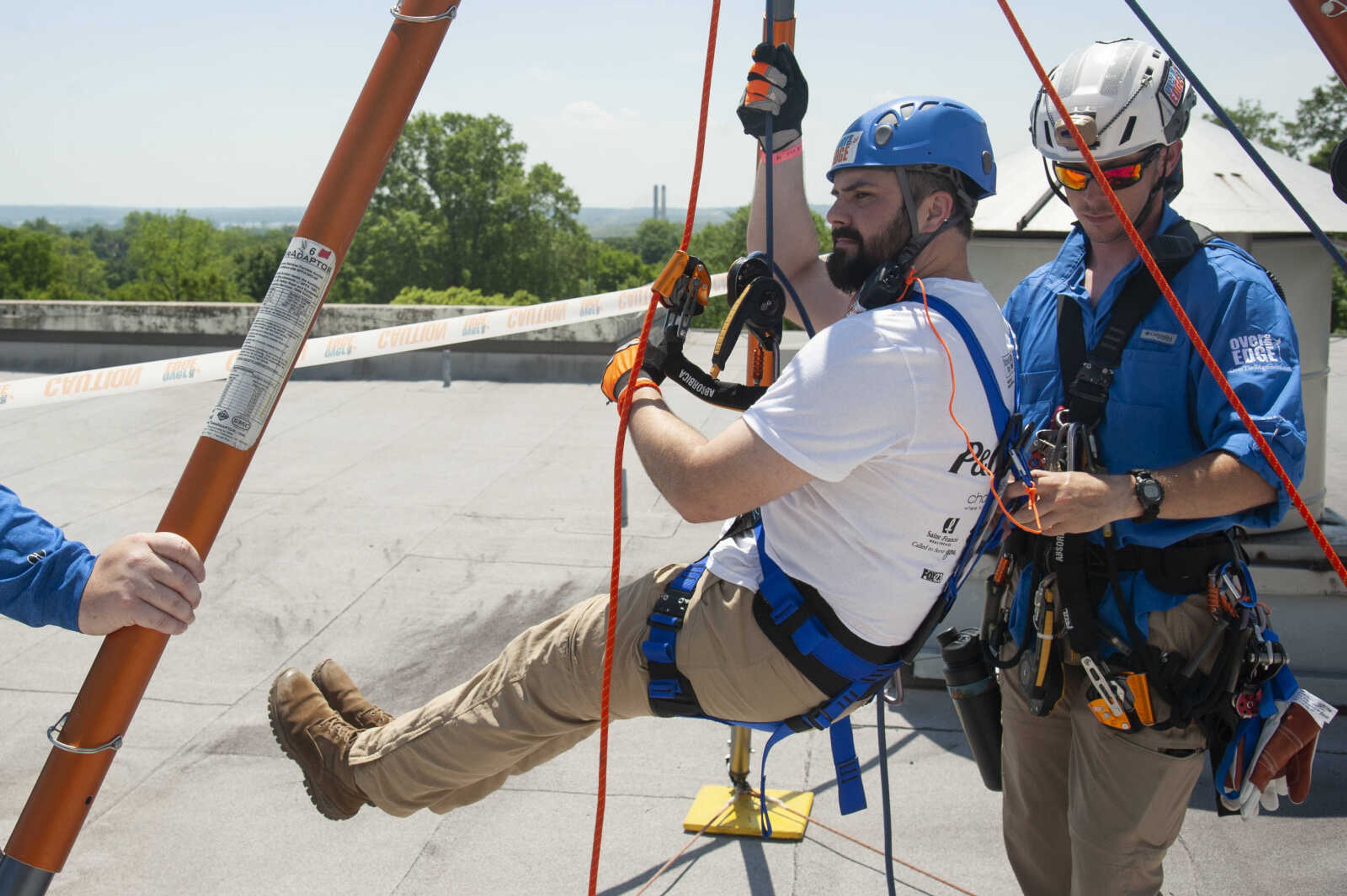 Mike Farinelli, originally of Scott Depot, W.Va., and now Cape Girardeau, is shown a procedure for rappelling from David Bright of Fayetteville, N.C., training manager for the Over the Edge event, during the United Way of Southeast Missouri's Over the Edge fundraising event Friday, May 17, 2019, at Southeast Missouri State University's Towers South dormitory in Cape Girardeau.