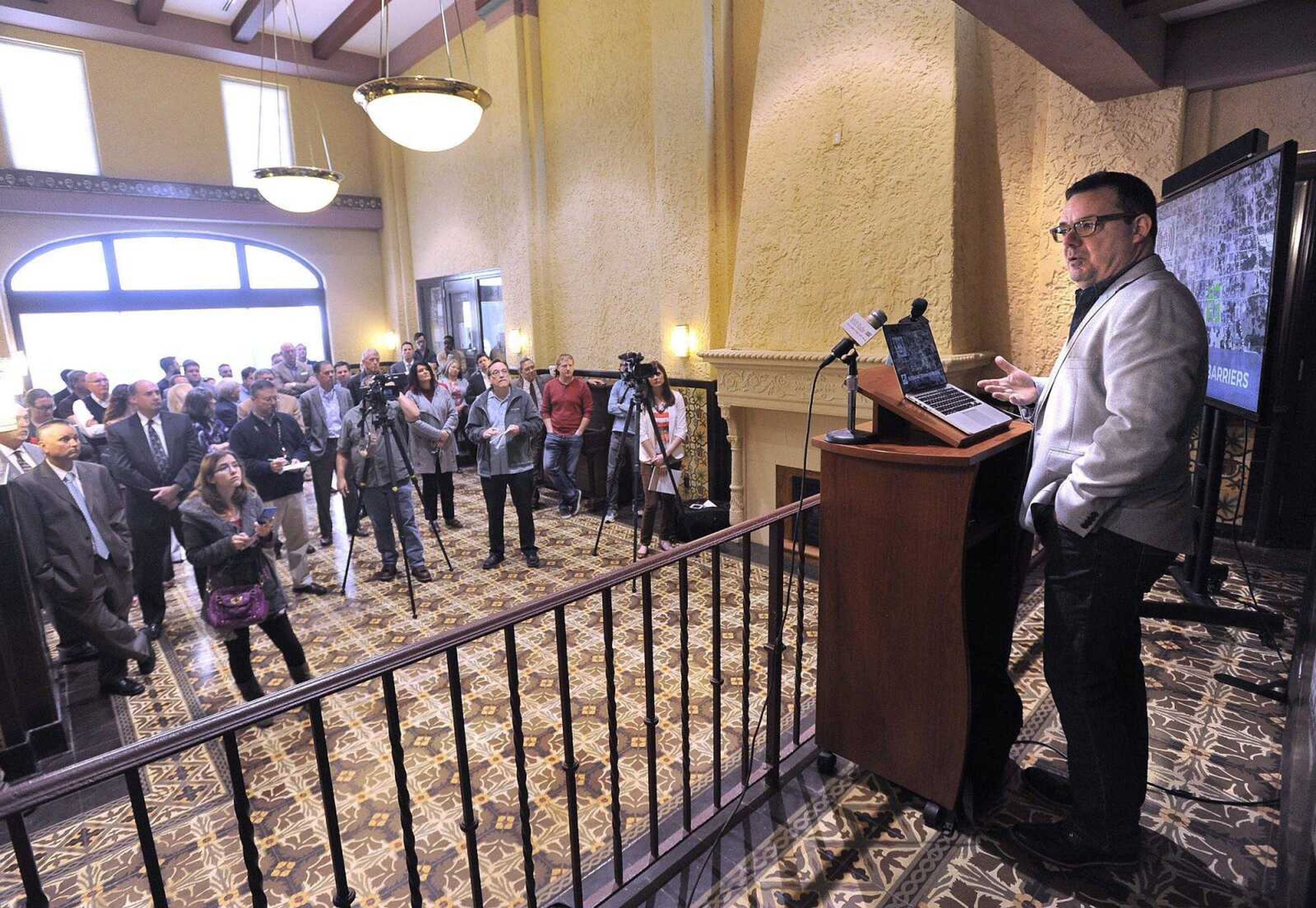 Dr. James Stapleton addresses an audience in the Marquette Tower lobby.