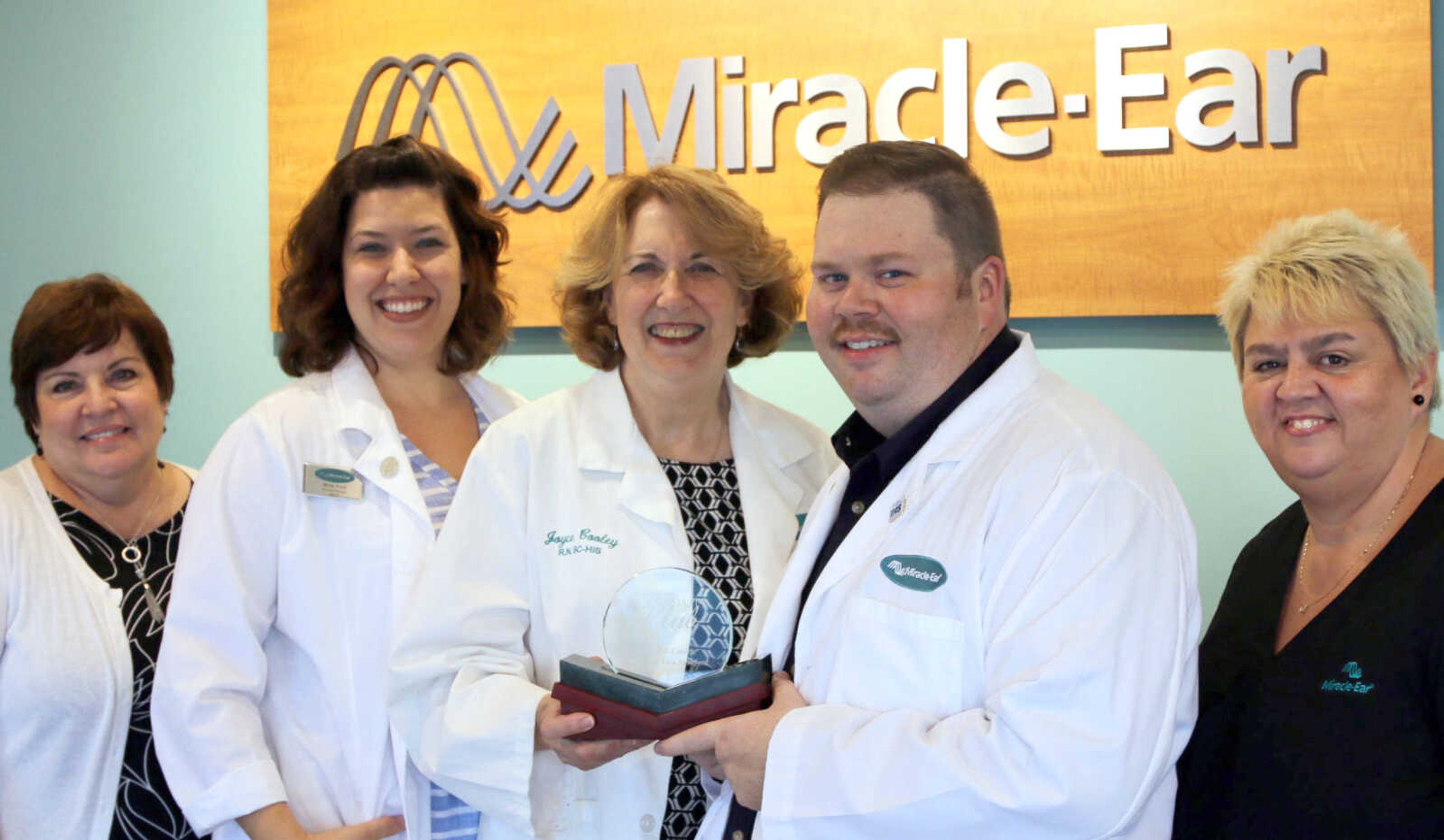 Miracle-Ear staff are shown with their ninth Platinum Club Award.