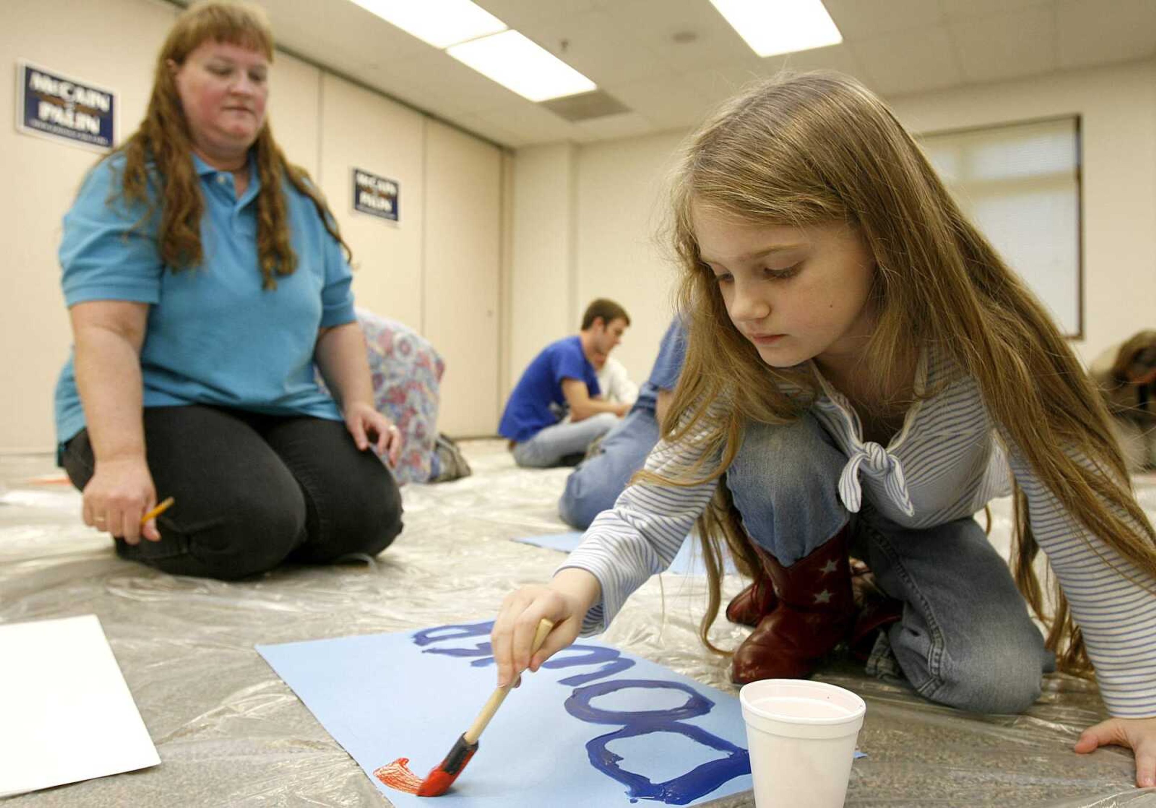 ELIZABETH DODD ~ edodd@semissourian.com
Dakota Jenkins, 7, of Cape Girardeau, right, makes a sign for Sarah Palin that says "Girl Power" with her mother Debra and brother Clint, not pictured, at the Osage Center Tuesday.