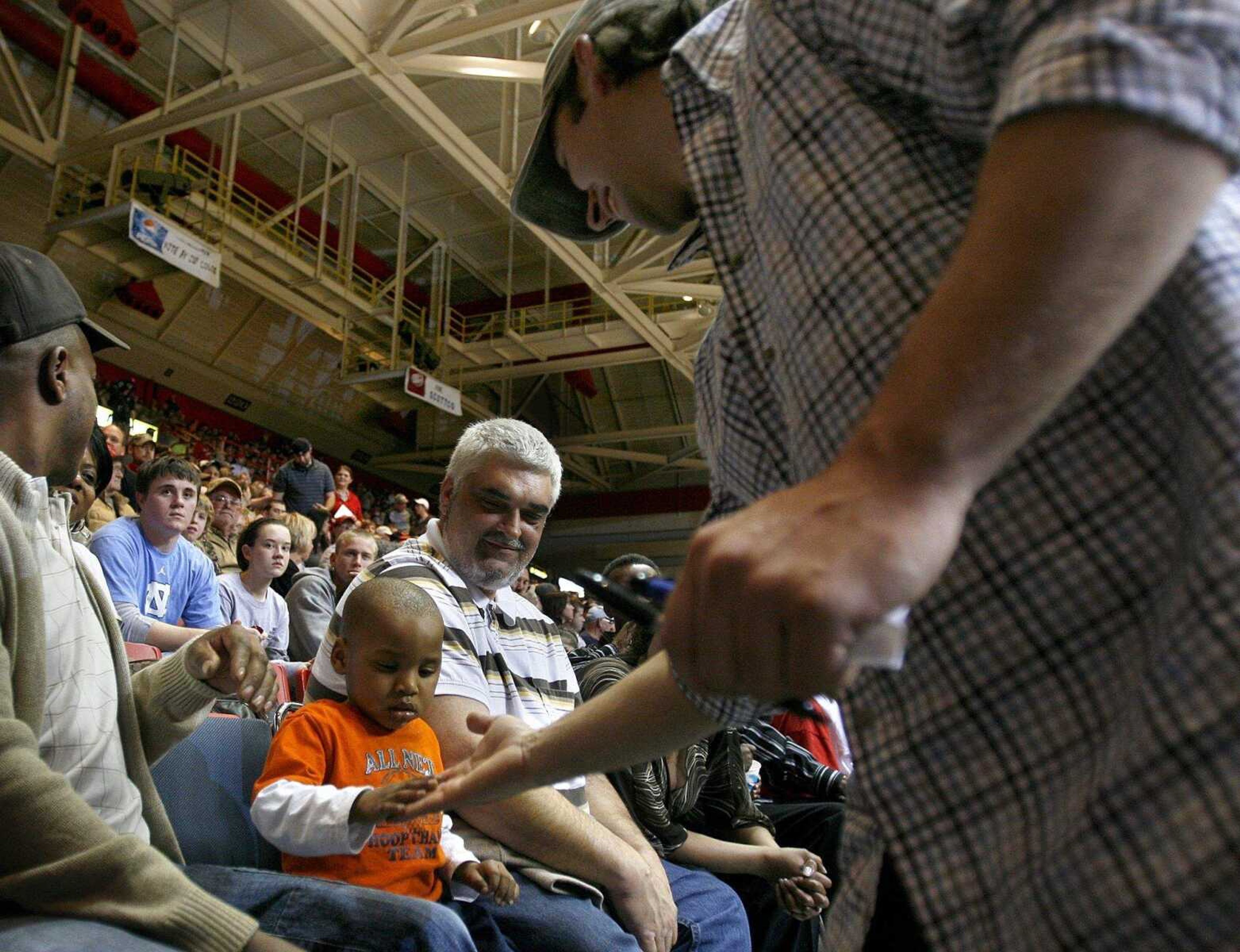 ELIZABETH DODD ~ edodd@semissourian.com
Los Angeles Dodger infielder and Sikeston graduate, Blake Dewitt, high fives Takerion, 2, after signing autographs at halftime.