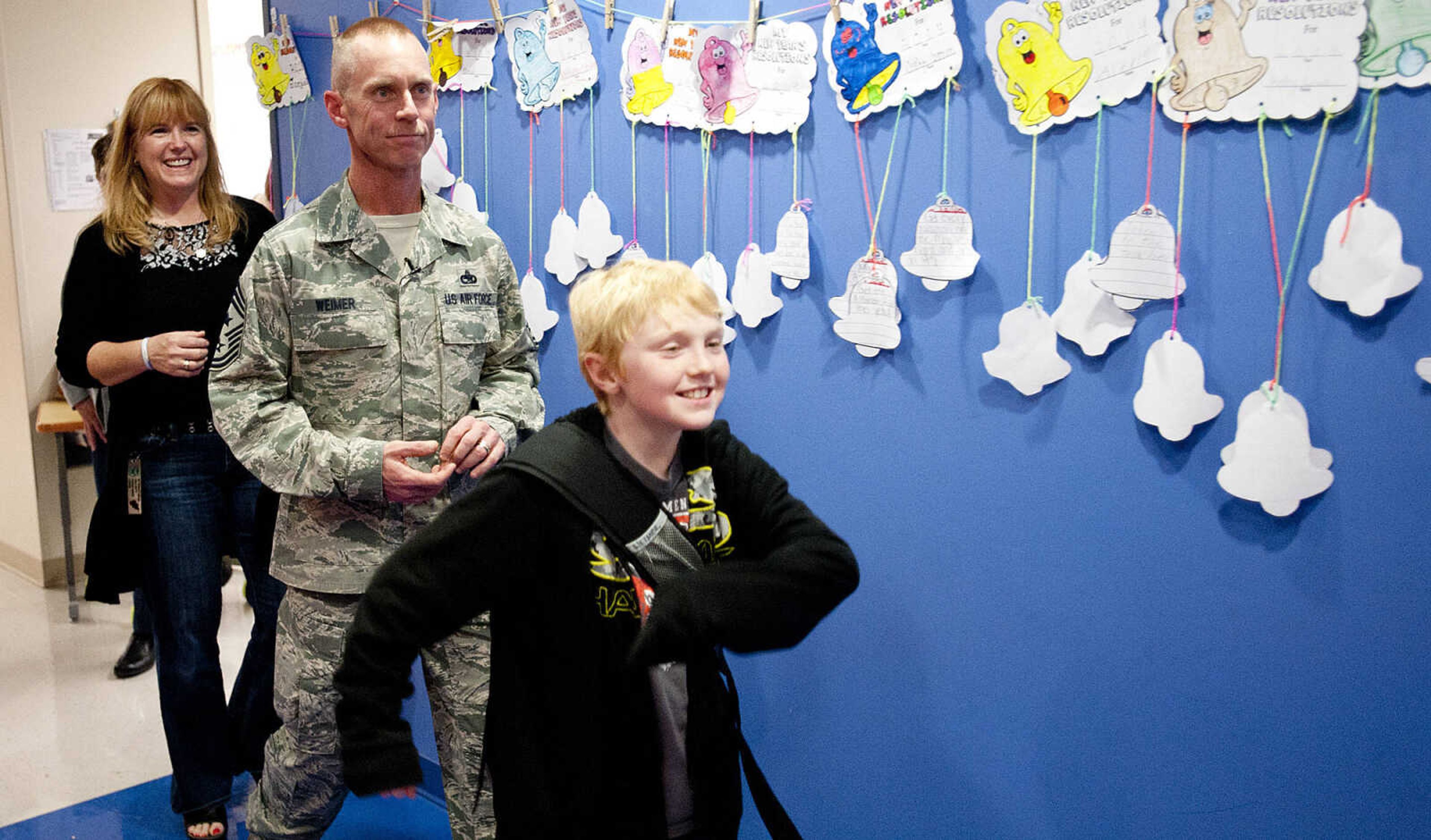 Eli Weimer, 9, leads his parents, Command Chief Master Sgt. Geoff Weimer and LeAnne Weimer down the hall to  the gym where his brother Gabriel's kindergarten class was having PE Friday, March 14, at Franklin Elementary School in Cape Girardeau. Sgt. Weimer is on leave from the Air Force after being deployed in the Middle East since Oct., and surprised his three sons, Geordan, 11, Eli, 9, and Gabriel, 6, in their respective classes.