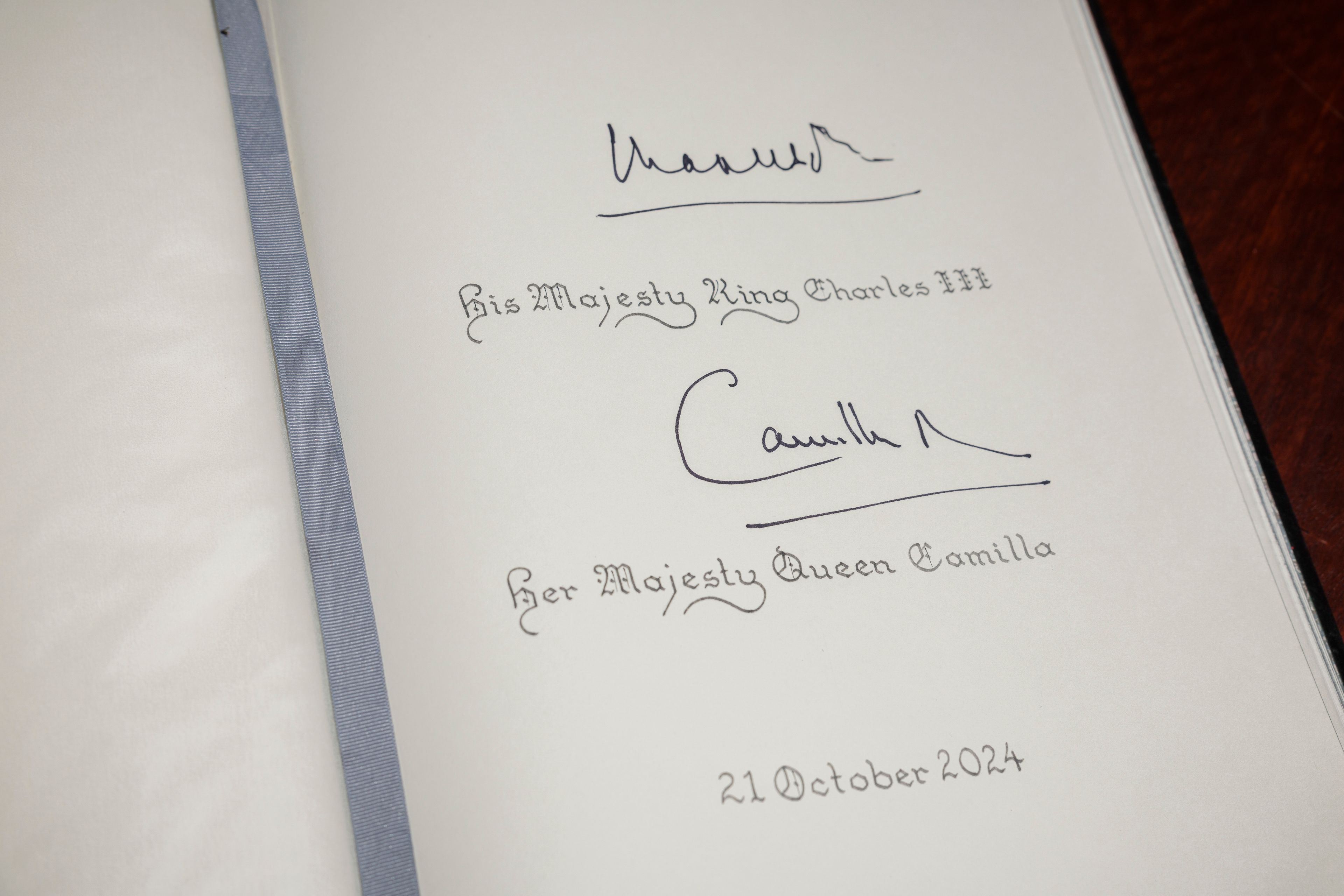 A visitor's book bearing the signatures of Britain's King Charles III and Queen Camilla is seen after they signed it at the Australian War Memorial in Canberra, Australia, Monday, Oct. 21, 2024. (Brook Mitchell/Pool Photo via AP)