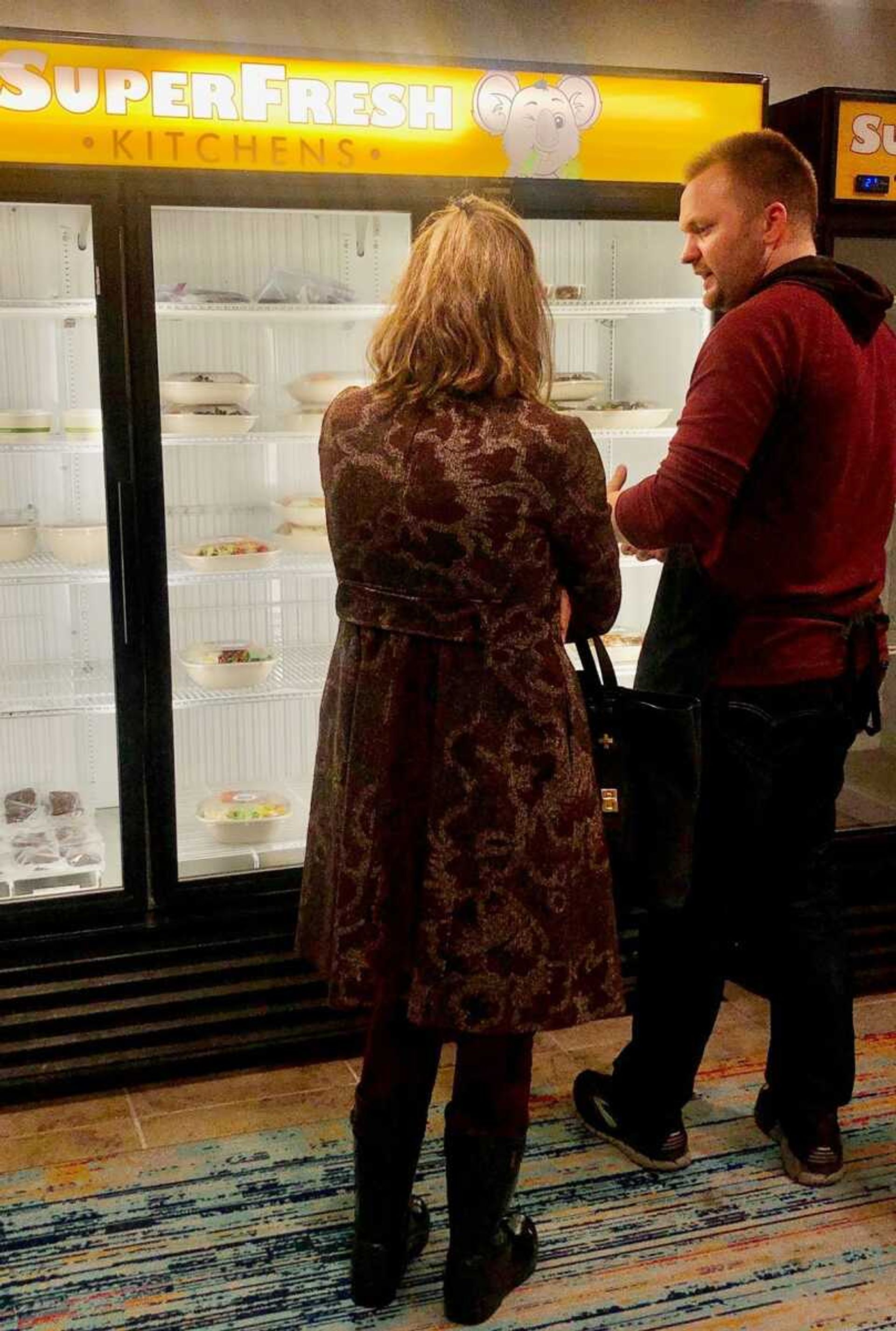 SuperFresh Kitchen founder Jeremy Roth assists customer Becky Harding.