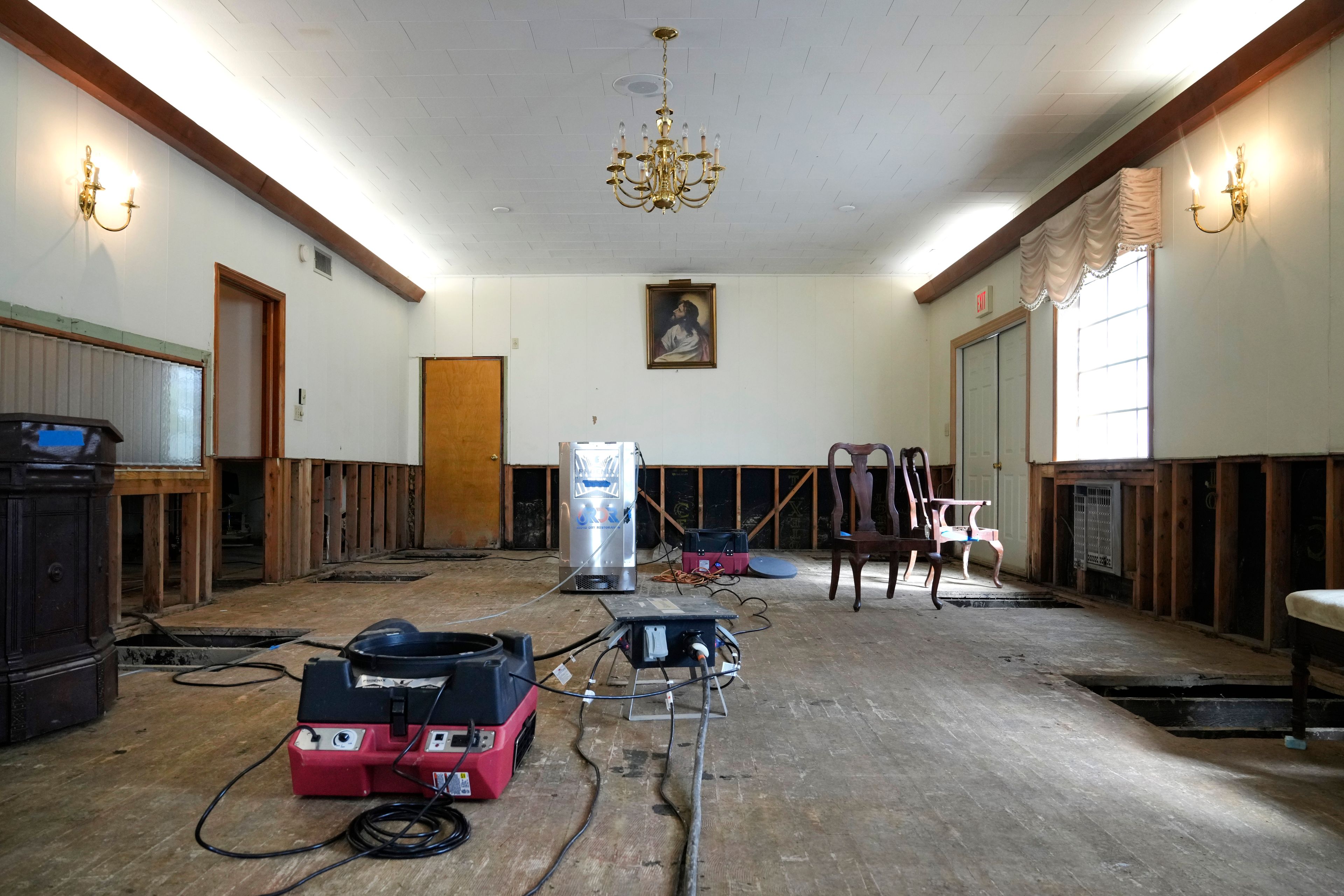 Air movers circulate the air in an effort to dry out the chapel inside Costner-Maloy Funeral Home Saturday, Oct. 5, 2024, which was flooded in the aftermath of Hurricane Helene, in Newport, Tenn. (AP Photo/Jeff Roberson)