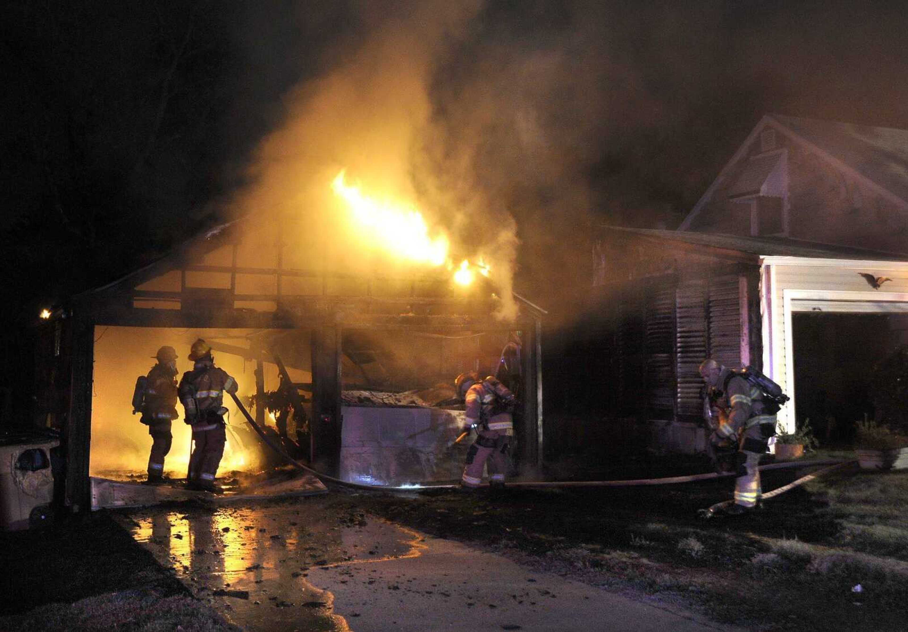 Cape Girardeau firefighters arrive at a garage fire next to a house Monday night on South Park Avenue in Cape Girardeau. A resident was inside the house at the time and was able to escape. (Fred Lynch)