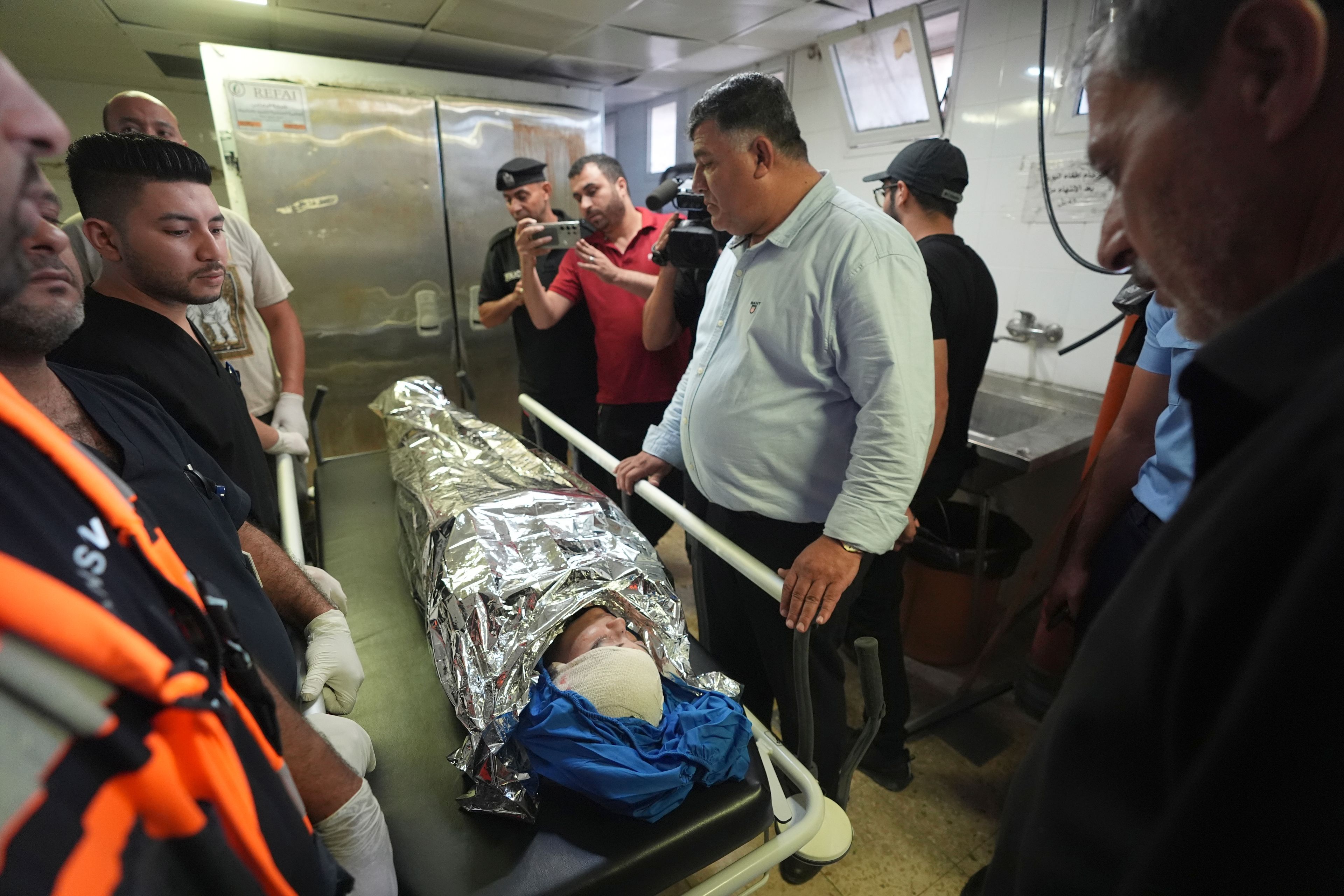 Palestinians gather around the body of Aysenur Ezgi Eygi, 26, who was fatally shot by Israeli soldiers while participating in an anti-settlement protest in the West Bank, at the morgue of the Rafedia hospital in the West Bank city of Nablus Friday, Sept. 6, 2024. (AP Photo)