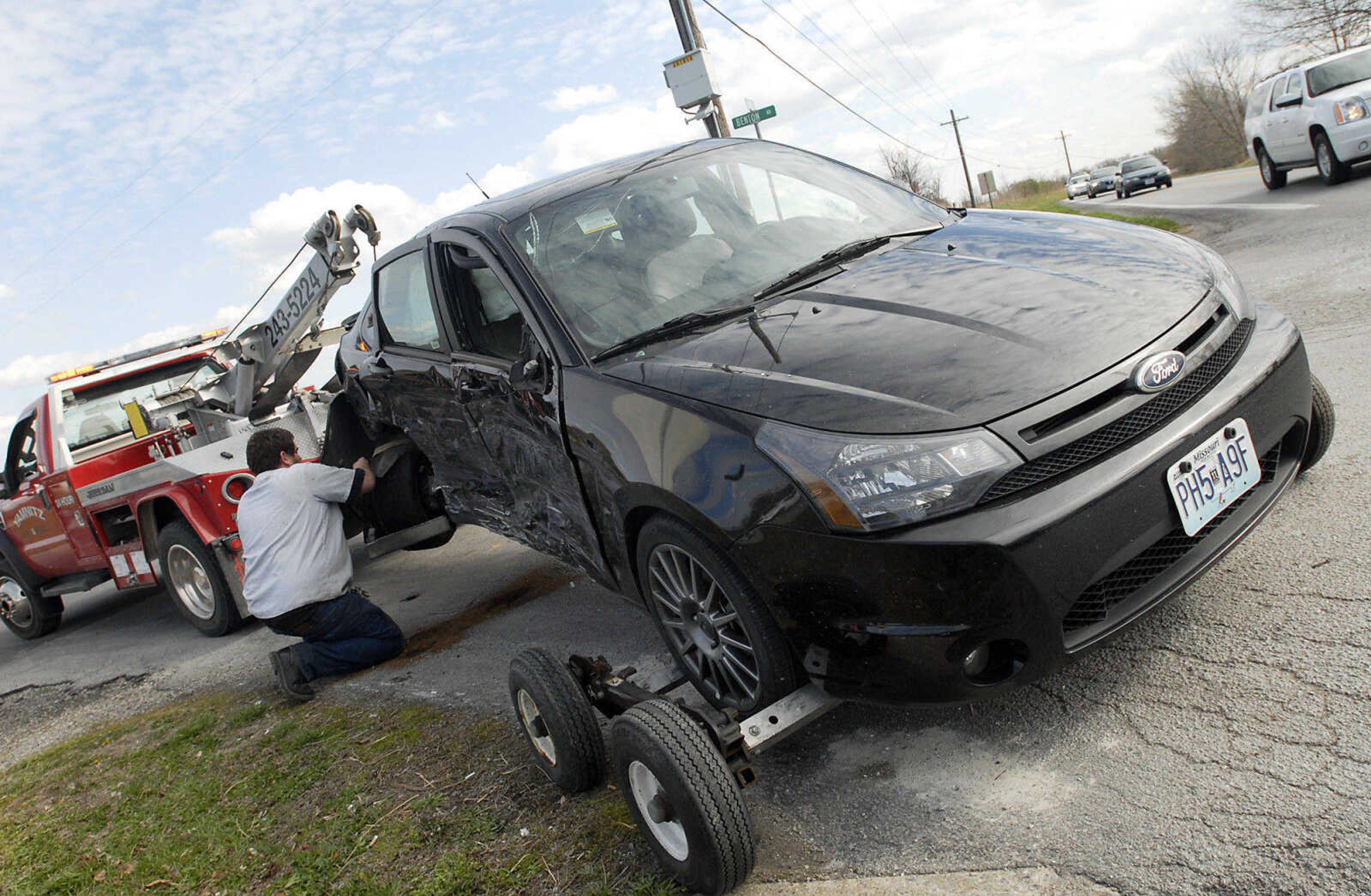 Traffic crawls by the intersection of South Hope Street and County Road 318 in Jackson as Steven Rankin, of Yamnitz Body and Frame, works to clear a car from the scene of a three-vehicle accident on Friday, April 1, 2011. No one sustained serious injuries. (Kristin Eberts)