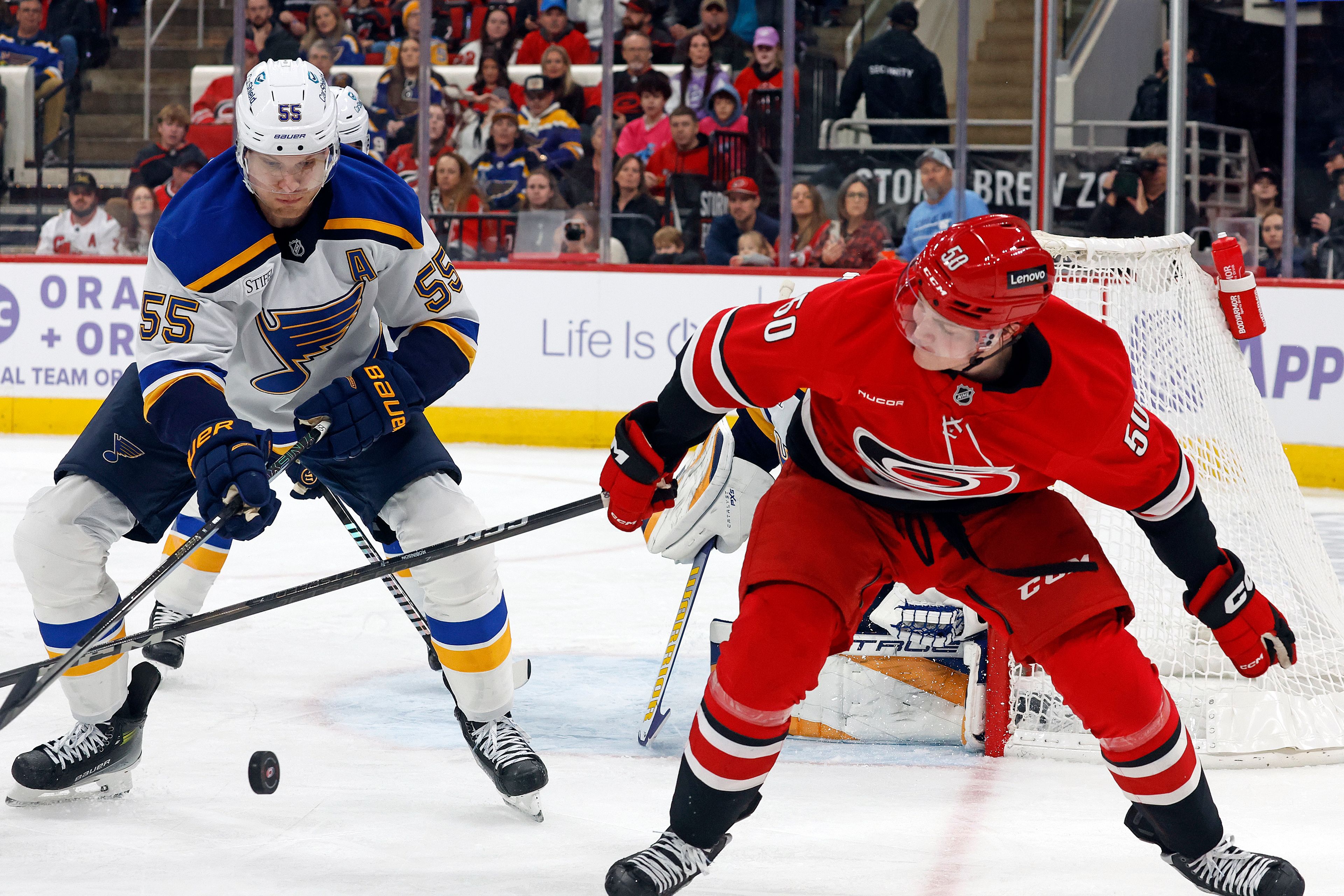 Carolina Hurricanes' Eric Robinson (50) looses control of the puck to St. Louis Blues' Colton Parayko (55) during the second period of an NHL hockey game in Raleigh, N.C., Sunday, Nov. 17, 2024. (AP Photo/Karl B DeBlaker)