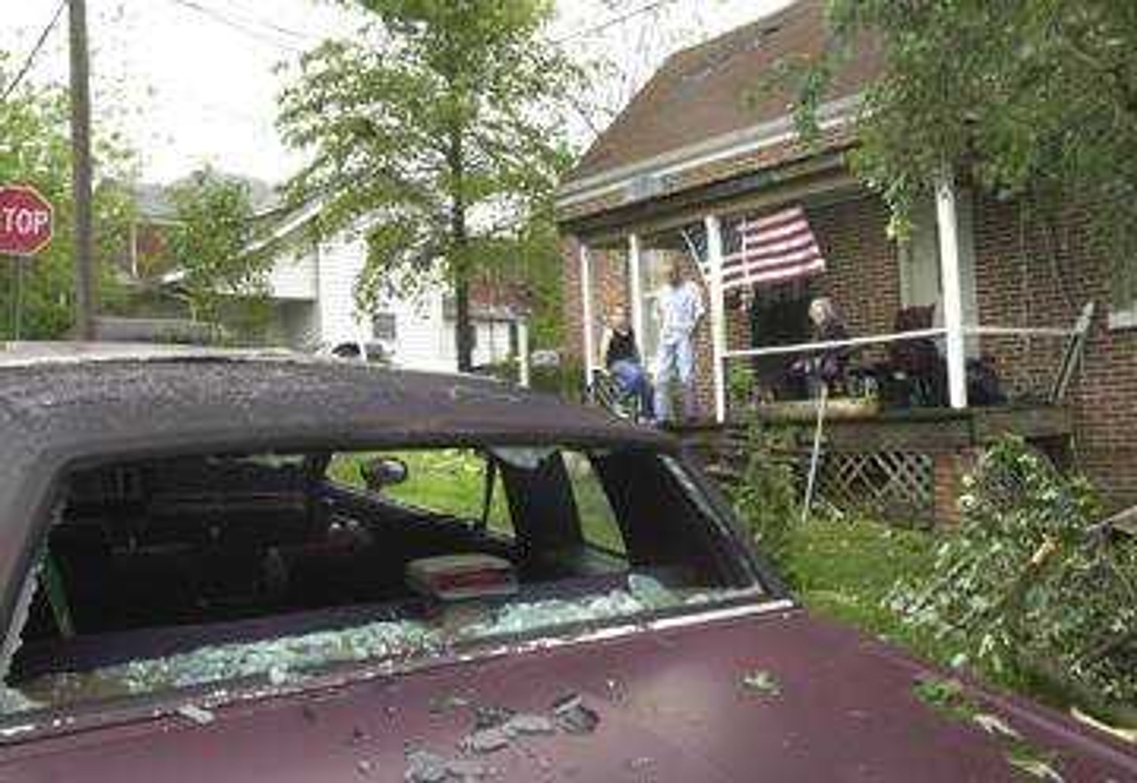 Members of the Mike Turberville family survey tornado damage from their East Adams street porch early Wednesday morning.