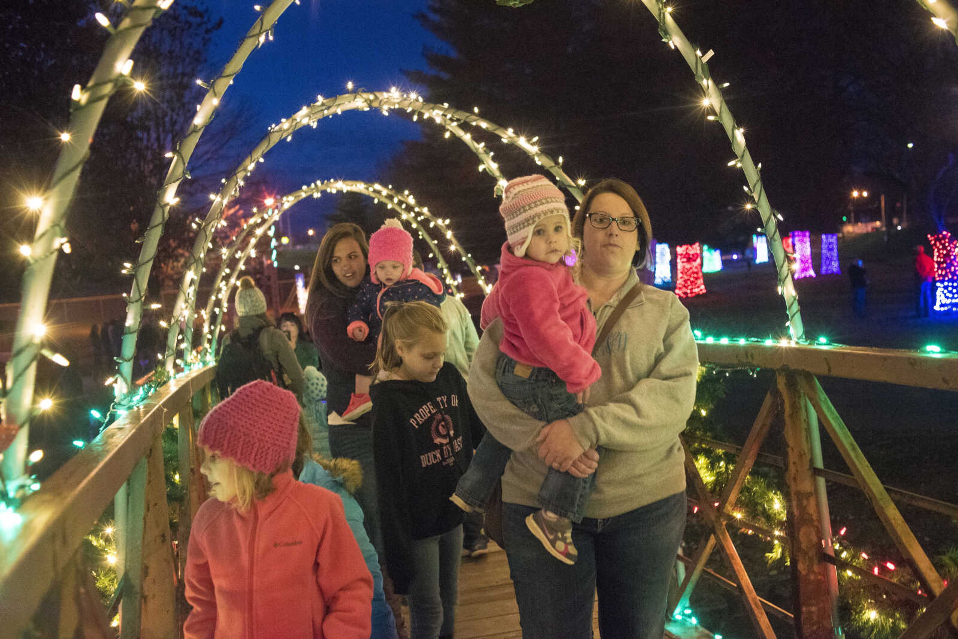 People walk the footbridge during the Jackson Holiday Extravaganza Friday, Nov. 24, 2017 at the Jackson City Park.