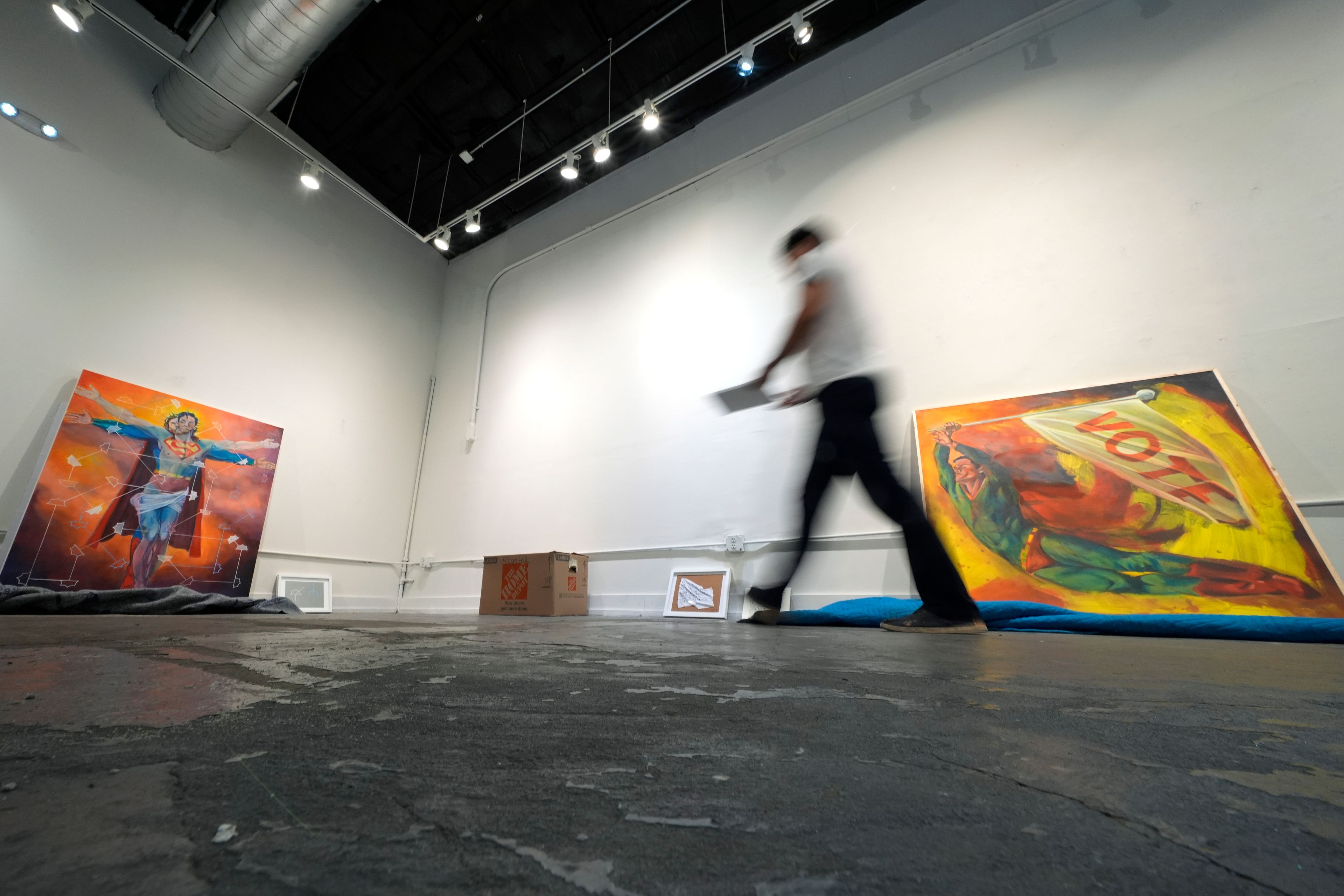 Artist David Alcantar prepares works of art from his "Superman Project" for an upcoming show in San Antonio, Monday, Sept. 30, 2024. (AP Photo/Eric Gay)