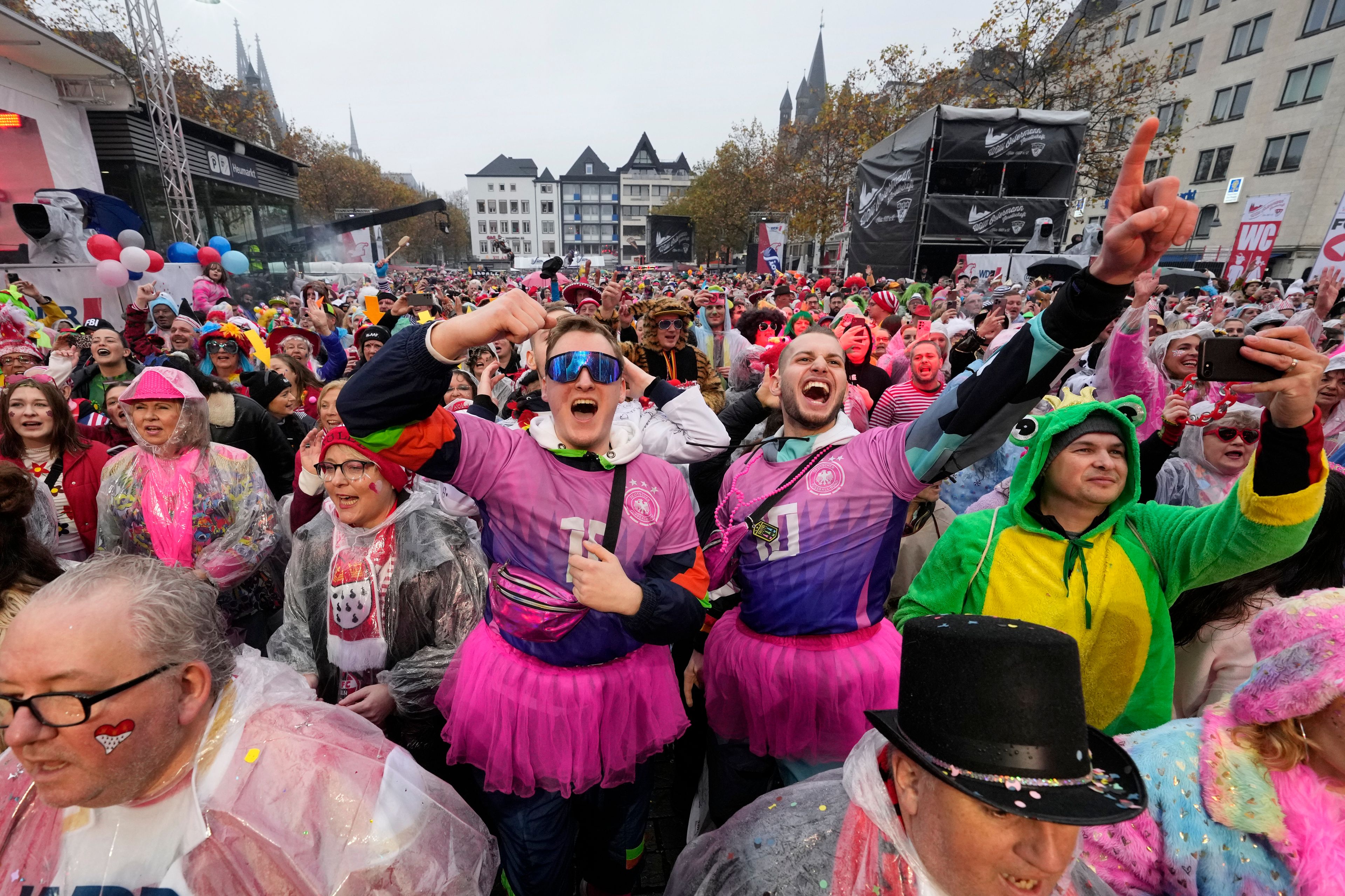 Costumed revelers celebrate at the central Heumarkt while tens of thousands of carnival fools take to the streets of Cologne, Germany, on Monday, November 11, 2024, heralding the official start of the carnival season.(AP Photo/Martin Meissner)