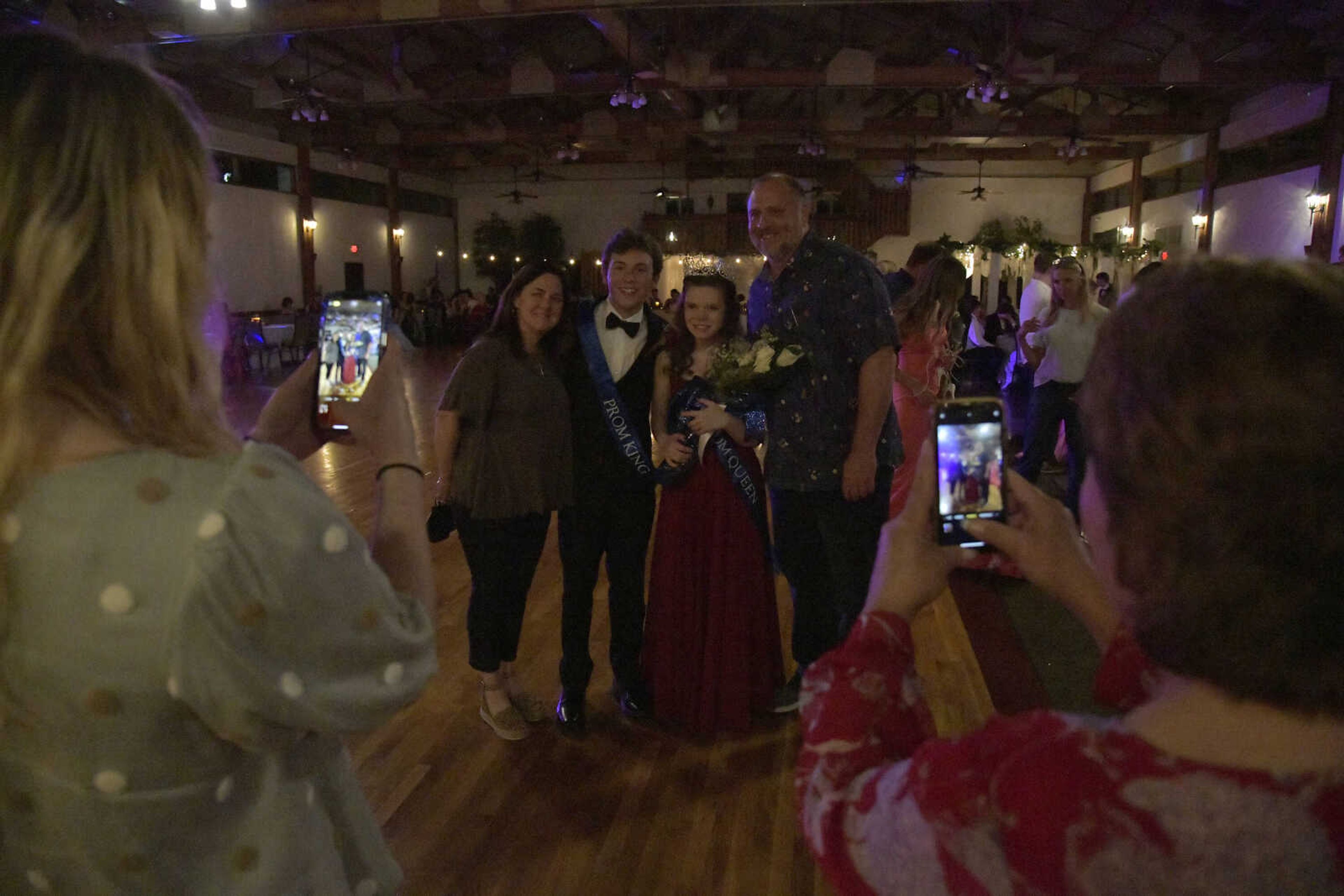 Ashlyn Baer and Nick Williams take a photo with her parents during Notre Dame's prom at Bavarian Halle in Jackson on Friday, April 30, 2021.