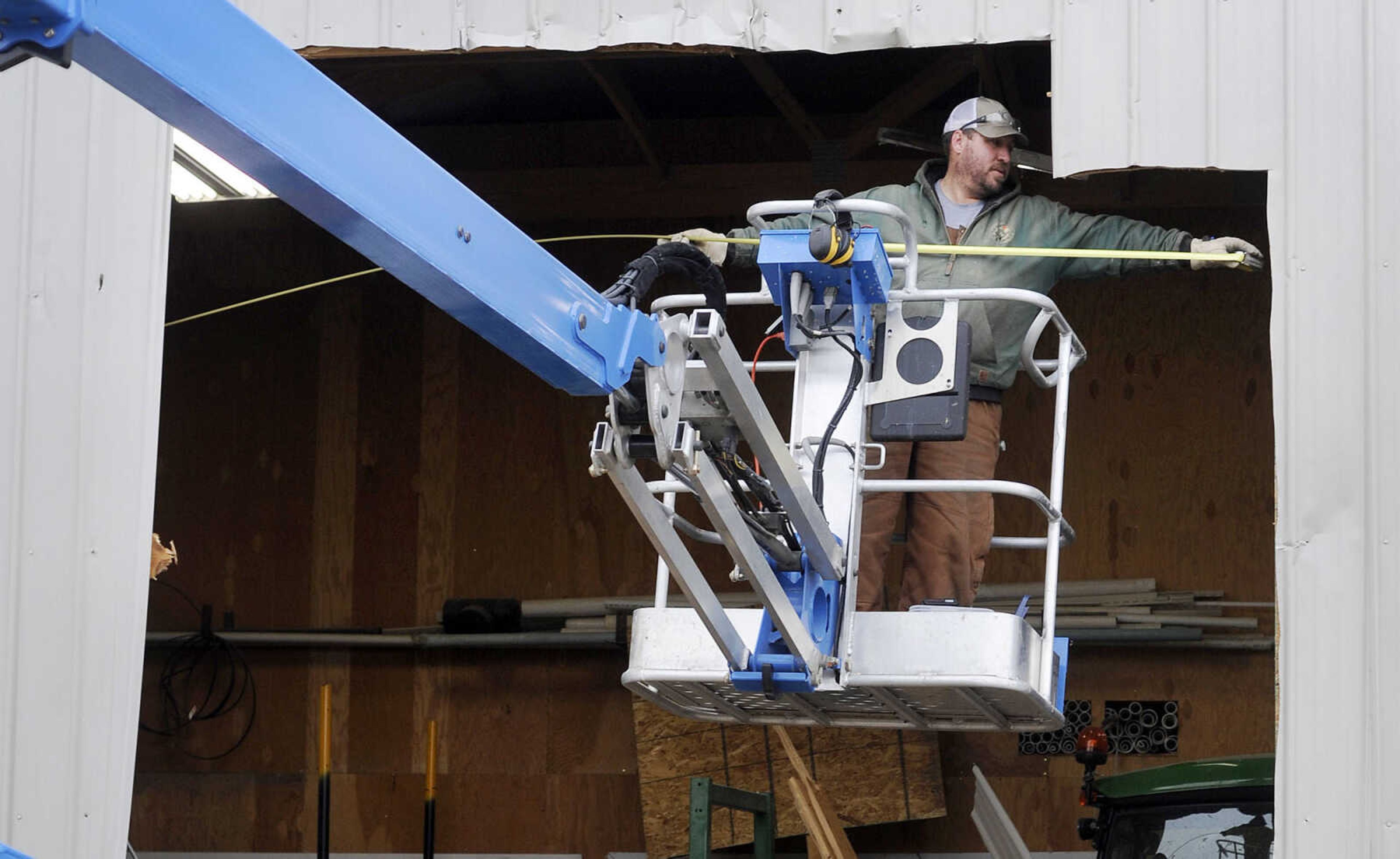 LAURA SIMON ~ lsimon@semissourian.com

Ryan Walthers measure the gap left behind by a sedan that crashed through the wall of an equipment shed at the Shawnee Park Sports Complex, Monday, Jan. 25, 2016, in Cape Girardeau. The vehicle crashed through the wall Sunday night, coming to rest on its nose. Members of the Cape Girardeau Parks and Recreation Department were working on a placing a temporary wall over the hole.