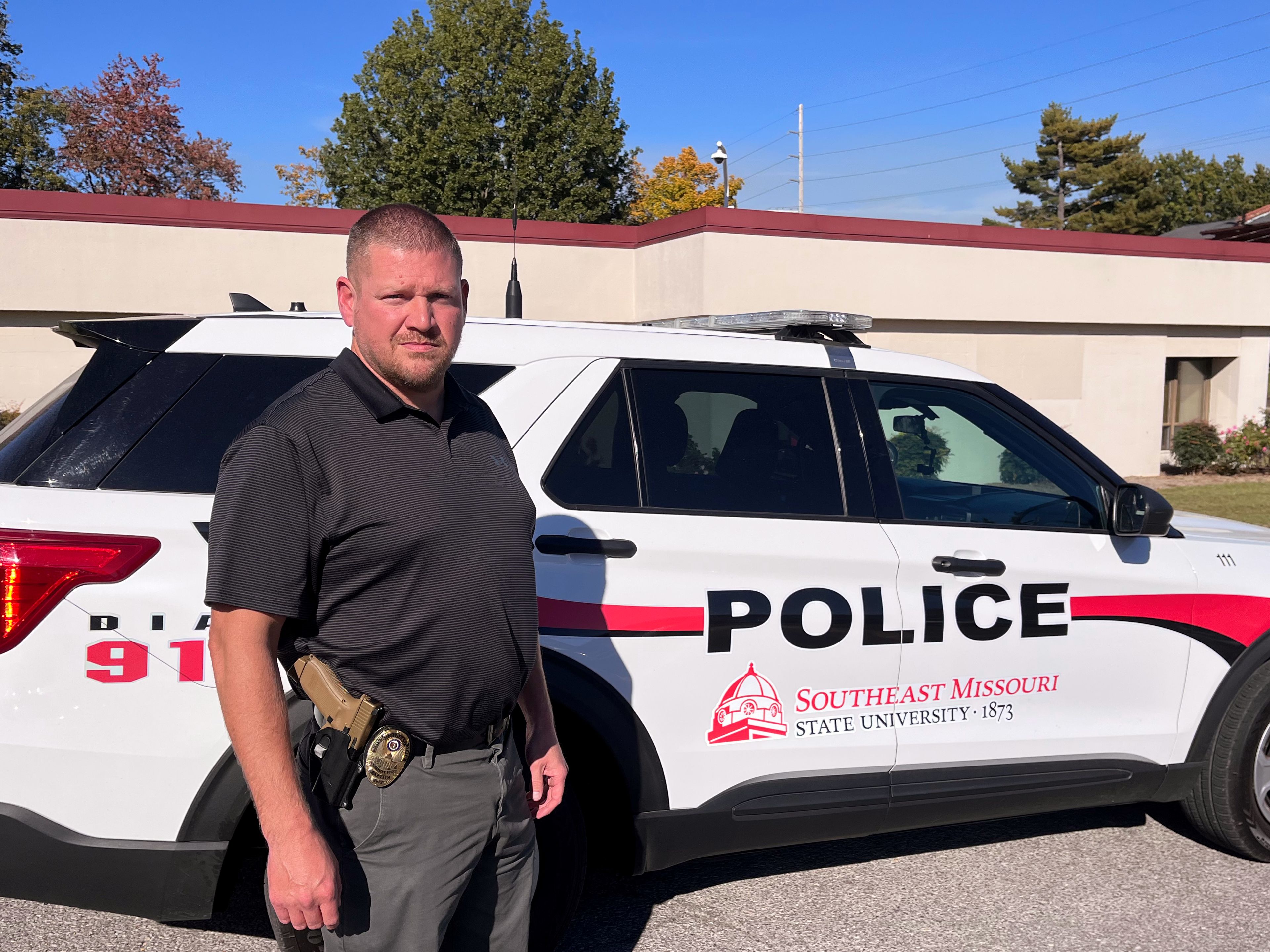 Southeast Missouri State University Department of Public Safety assistant director and captain of police operations Jason Morgan poses for a photo next to a DPS vehicle. 