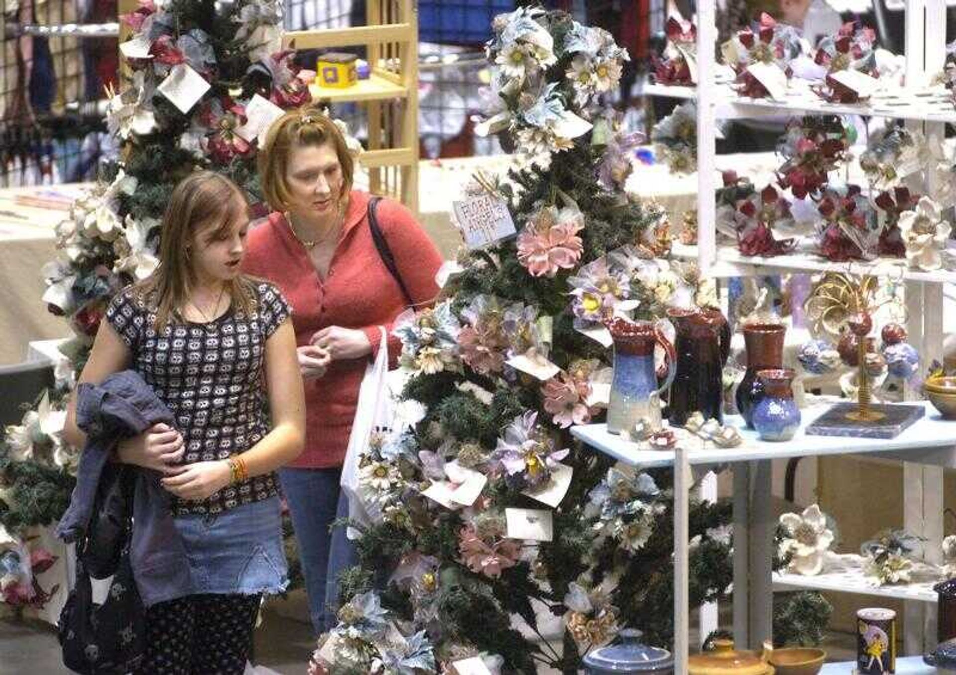 Aerial Minor, left, and her mother, Stephanie Niswonger, both of Cape Girardeau, looked at floral angels at the Christmas Arts and Crafts Extravaganza in the Show Me Center on Sunday. Sponsored by the Arts Council of Southeast Missouri, the annual event raises about one-half of the organization's funding. (Fred Lynch)