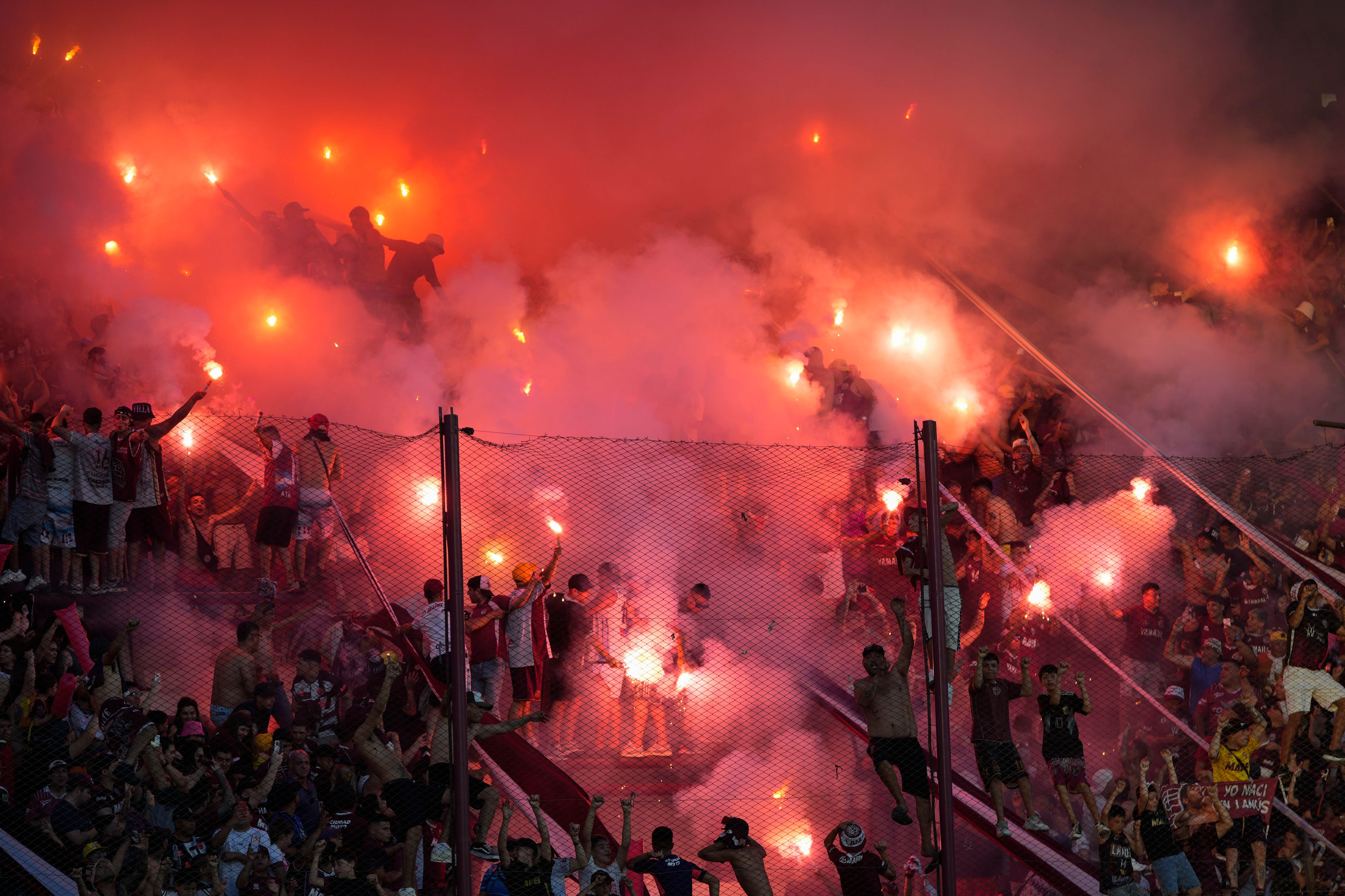 Fans of Argentina's Lanus launch fireworks before the start of a Copa Sudamericana semifinal second leg soccer match against Brazil's Cruzeiro at La Fortaleza Stadium in Buenos Aires, Argentina, Wednesday, Oct. 30, 2024. (AP Photo/Natacha Pisarenko)