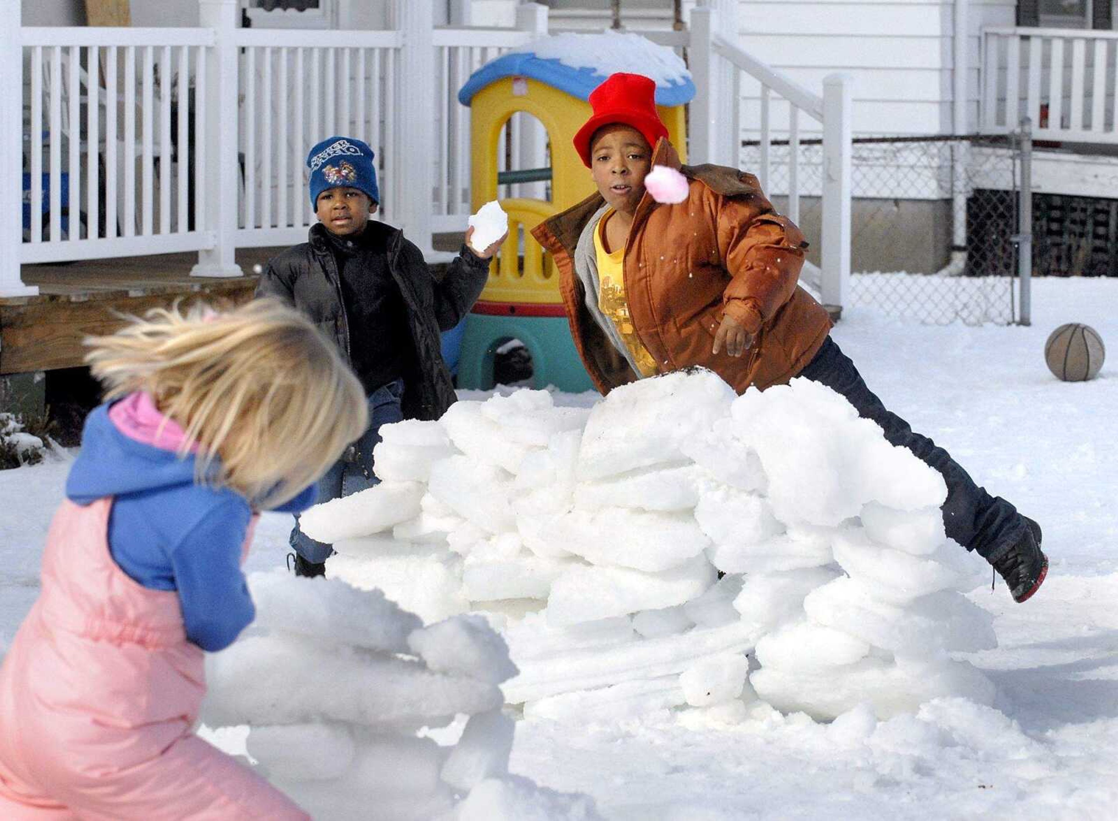 ELIZABETH DODD ~ edodd@semissourian.com
With snow forts built for protection, Justin Robinson, right, and his cousin Keion Davis throw snowballs at neighbor Desirea Eldridge and her brother Holden, not pictured, at their home Friday in Cape Girardeau on Henderson Avenue. Due to falling ice the kids built the fort in the front yard with less trees.