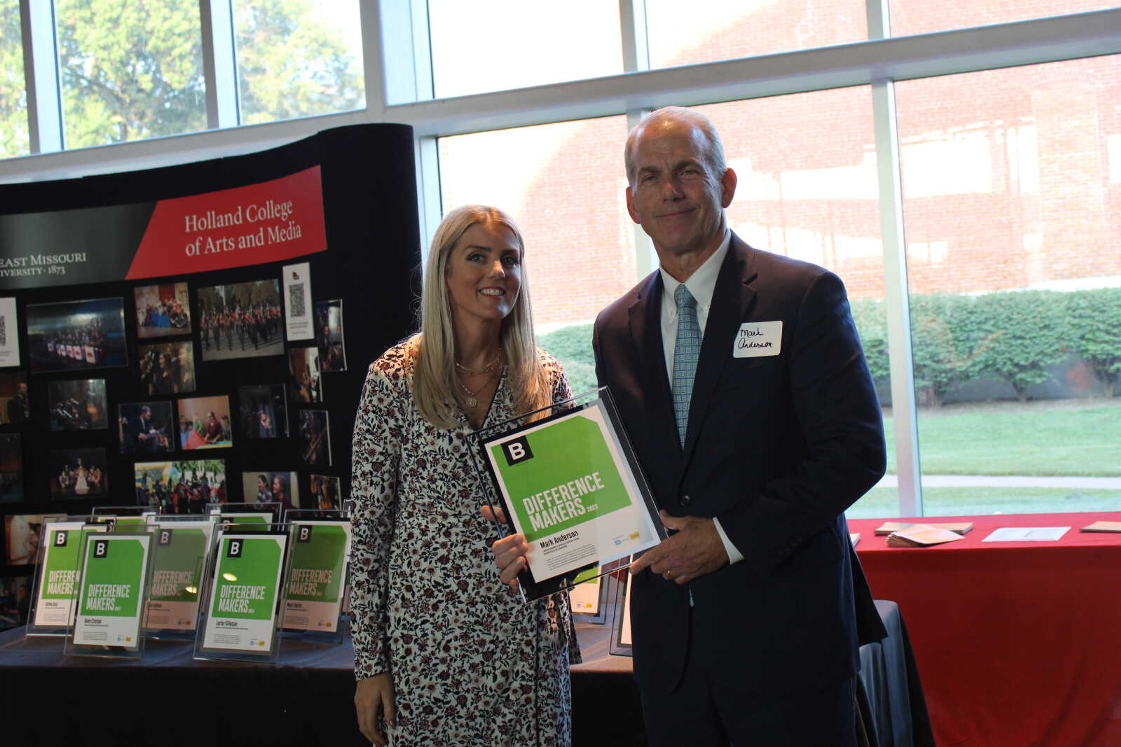 Edward Jones financial advisor Brooke Roth hands Difference Maker Mark Anderson his award.