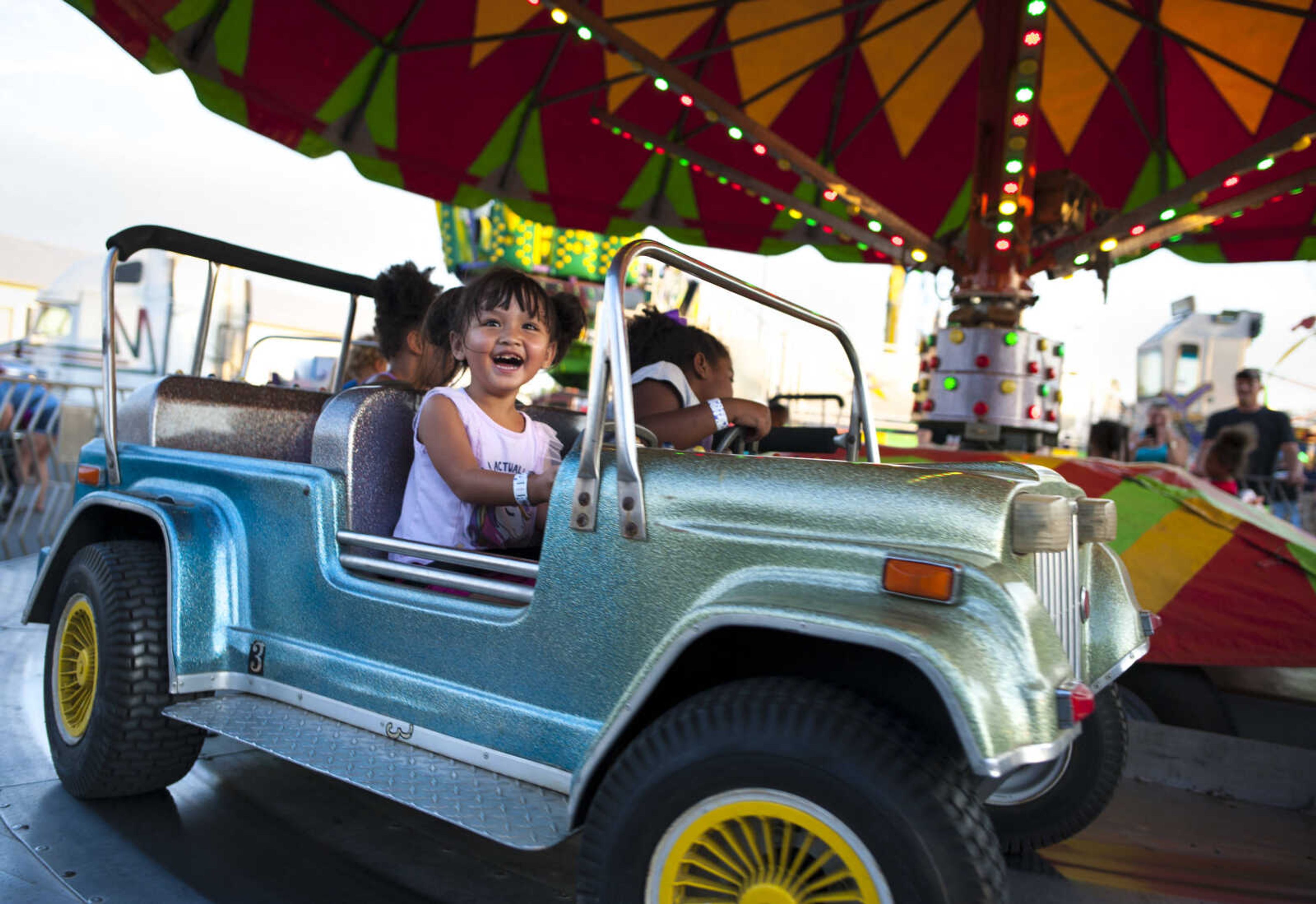 Sara Sith, 3, of Cape Girardeau, laughs while riding an attraction in the midway Tuesday, Sept. 10, 2019, during the SEMO District Fair at Arena Park in Cape Girardeau.