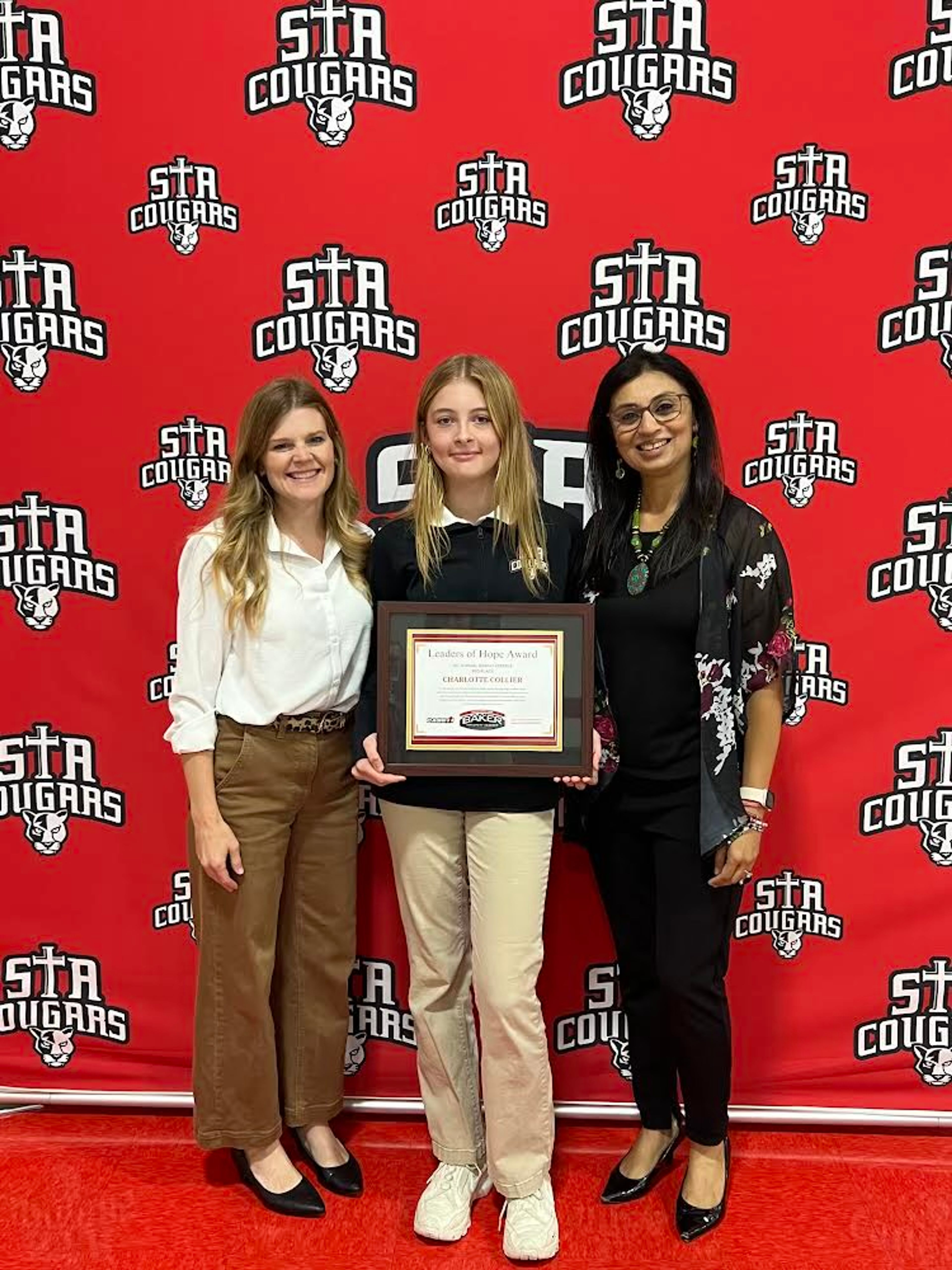 St. Augustine student Charlotte Collier, middle, poses for a photo with principal Katie Hendricks, left, and counselor Preeti Mungee after receiving her Leaders of Hope Award.