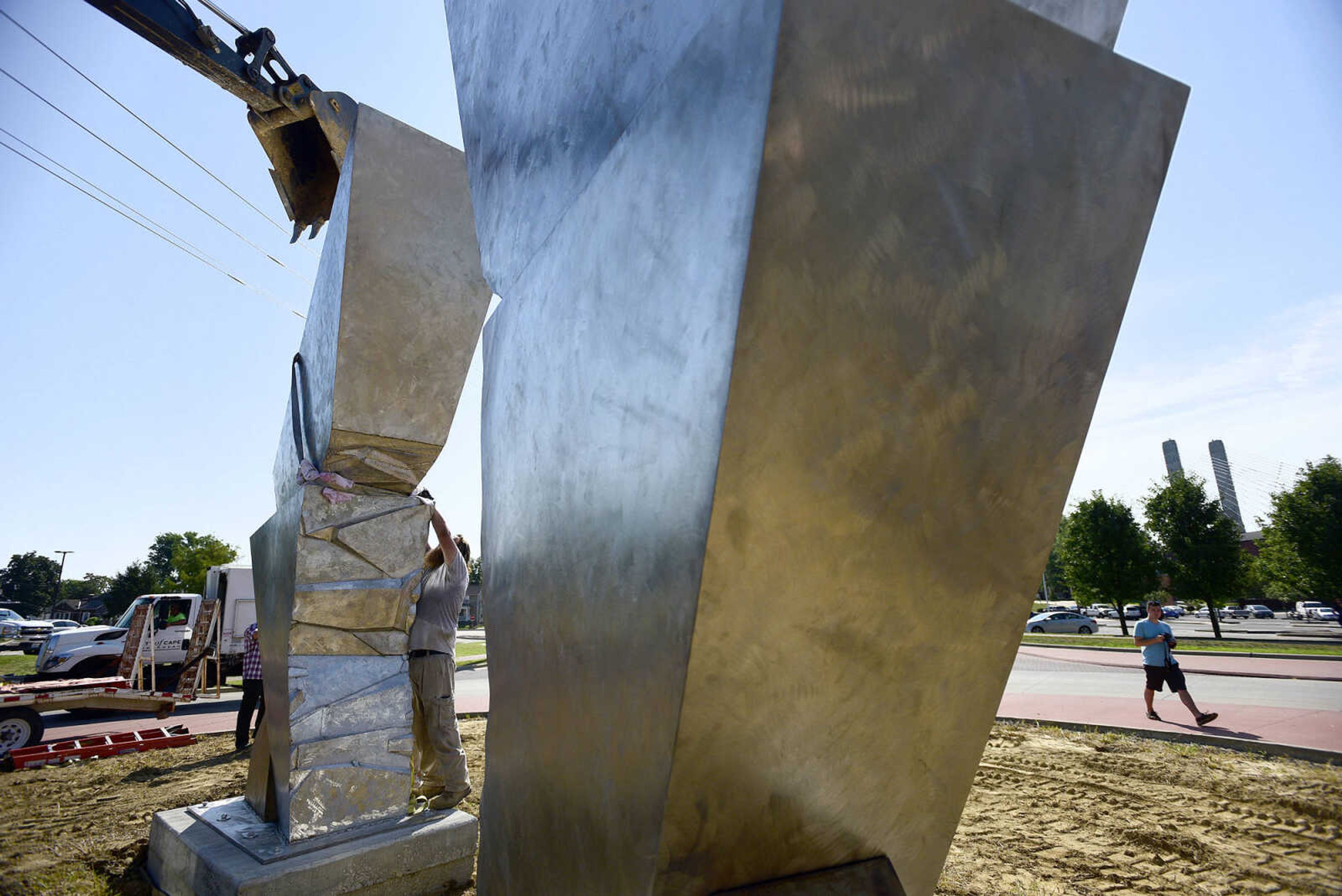 Cape Girardeau Parks and Recreation employees install the second piece of Chris Wubbena's 14-foot sculpture, "Commence", in the Fountain Street roundabout on Monday, July 24, 2017, near the River Campus in Cape Girardeau.