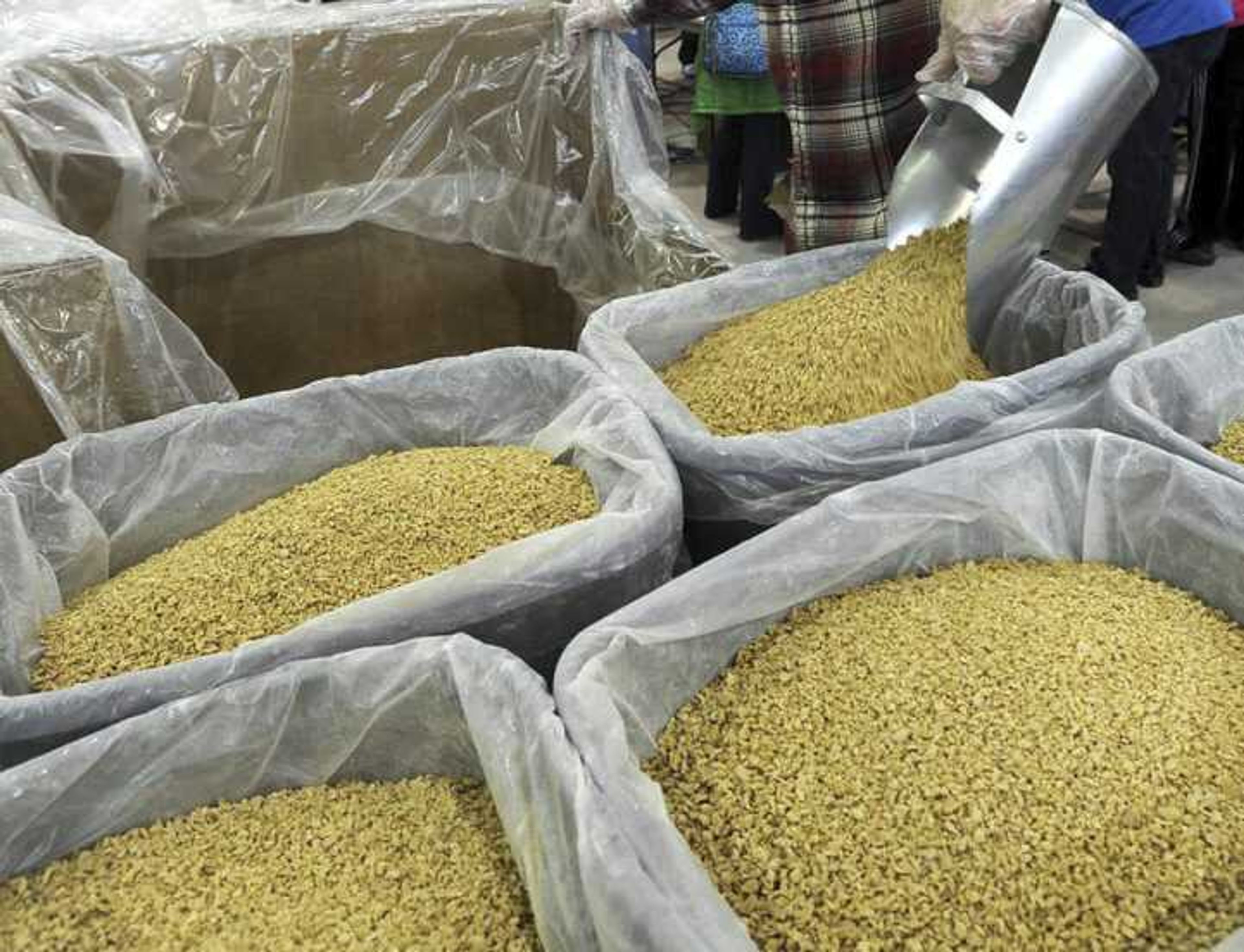 Soy is scooped into tubs for the packing lines at the Feed My Starving Children MobilePack event Sunday, Dec. 7, 2014, at the Osage Centre in Cape Girardeau.