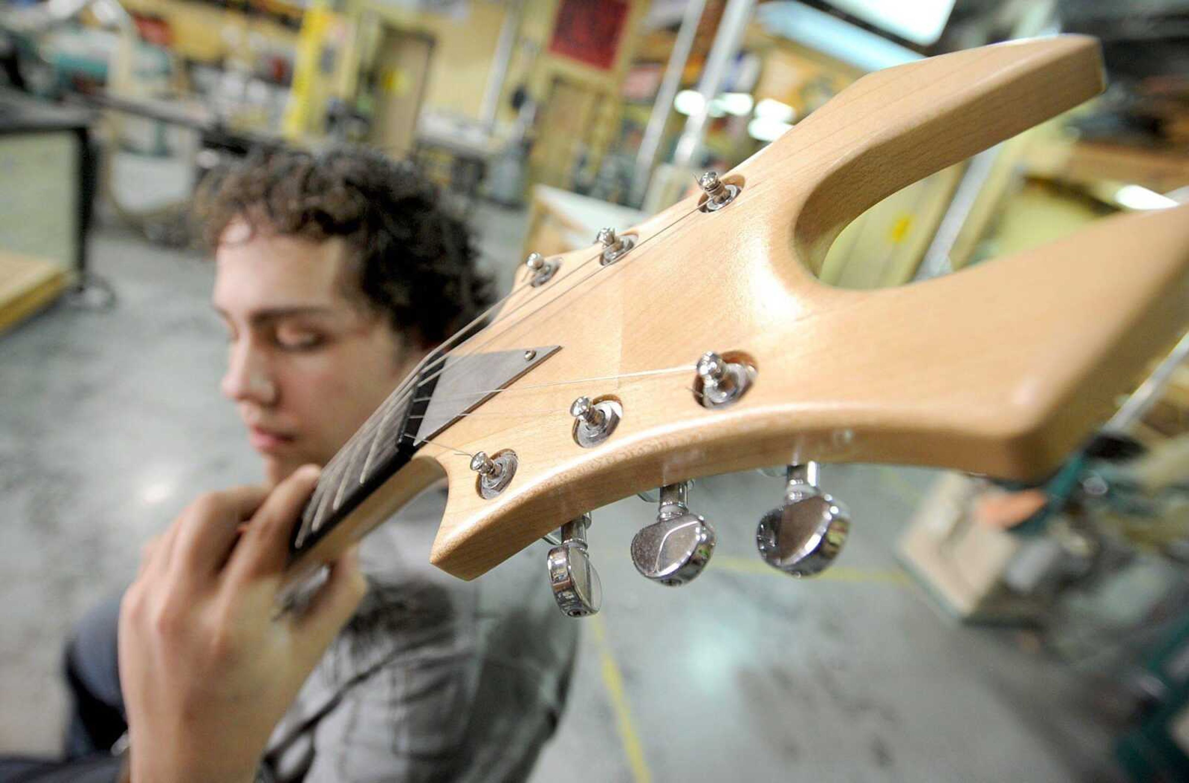 Chaffee High School senior Zach Perkins strums the guitar he made his junior year in his Chaffee Industrial Arts class Tuesday, March 27, 2012. Perkins is using a spider web design for his current guitar project. (Laura Simon)